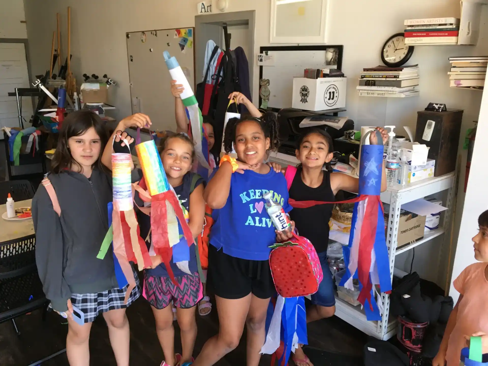 a group of girls holding up a couple of bags