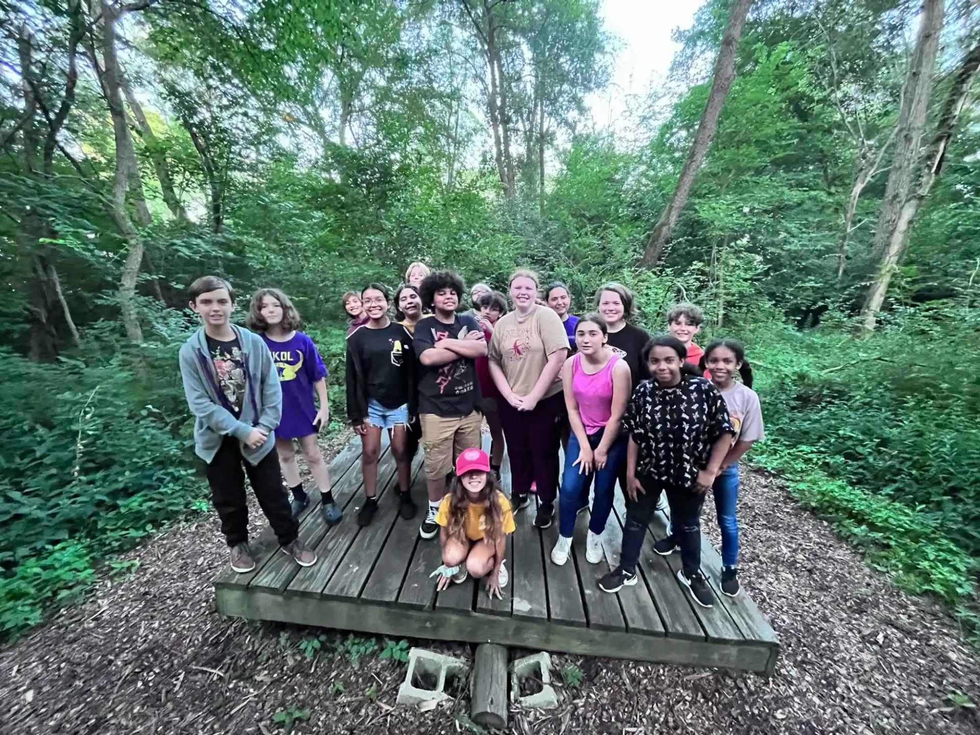 a group of people posing for a photo in the woods