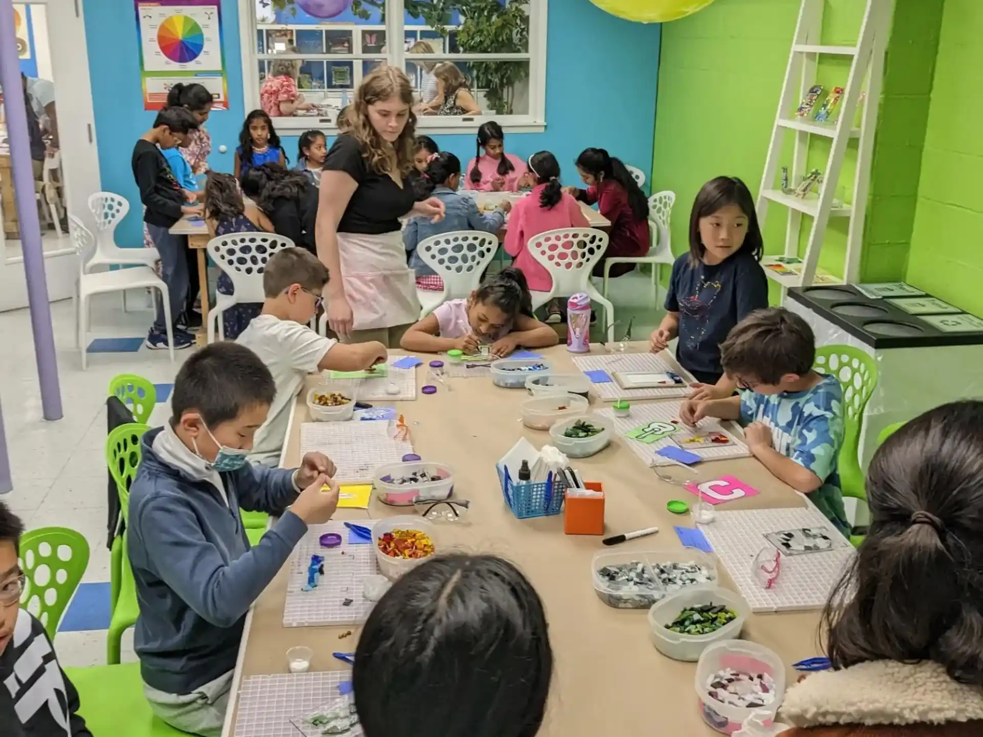 a group of children sitting around a table with balloons