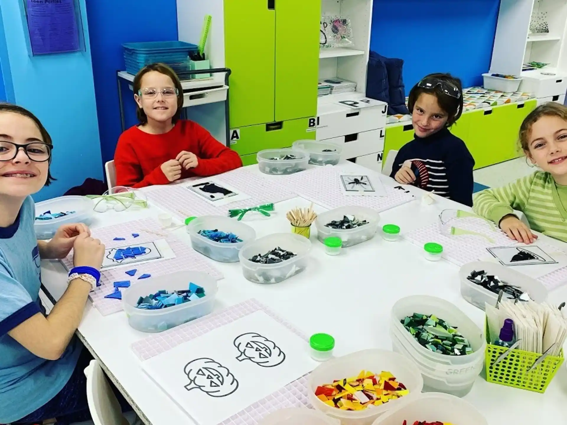 a group of children sitting at a table with food