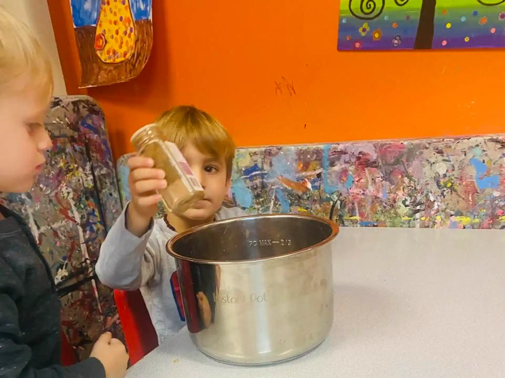 a couple of kids drinking from a cup