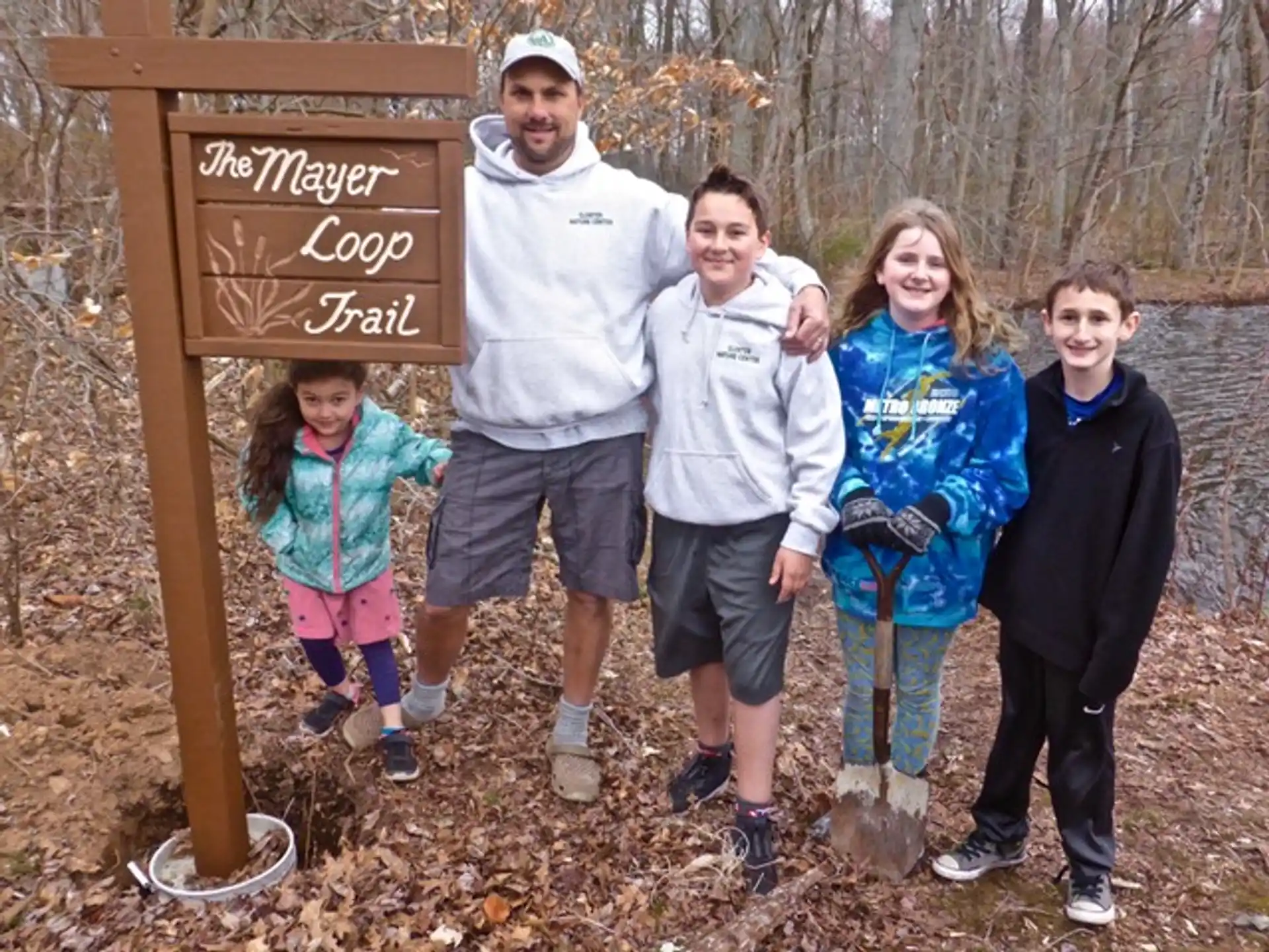 a group of people posing for a photo in front of a sign