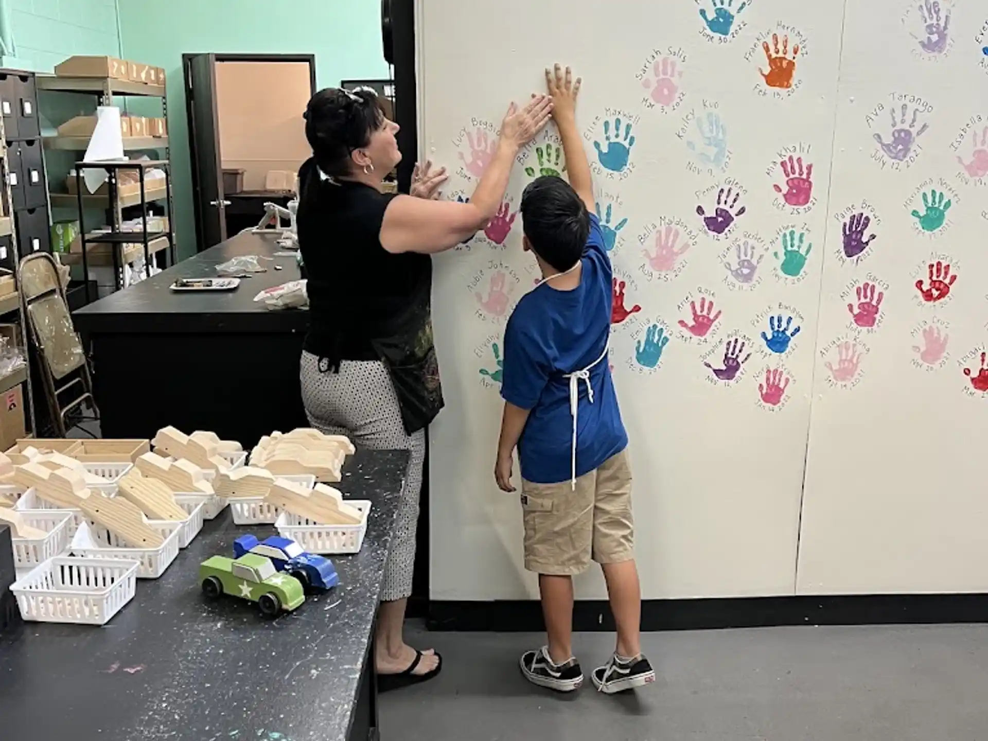 a couple of people painting on a white board