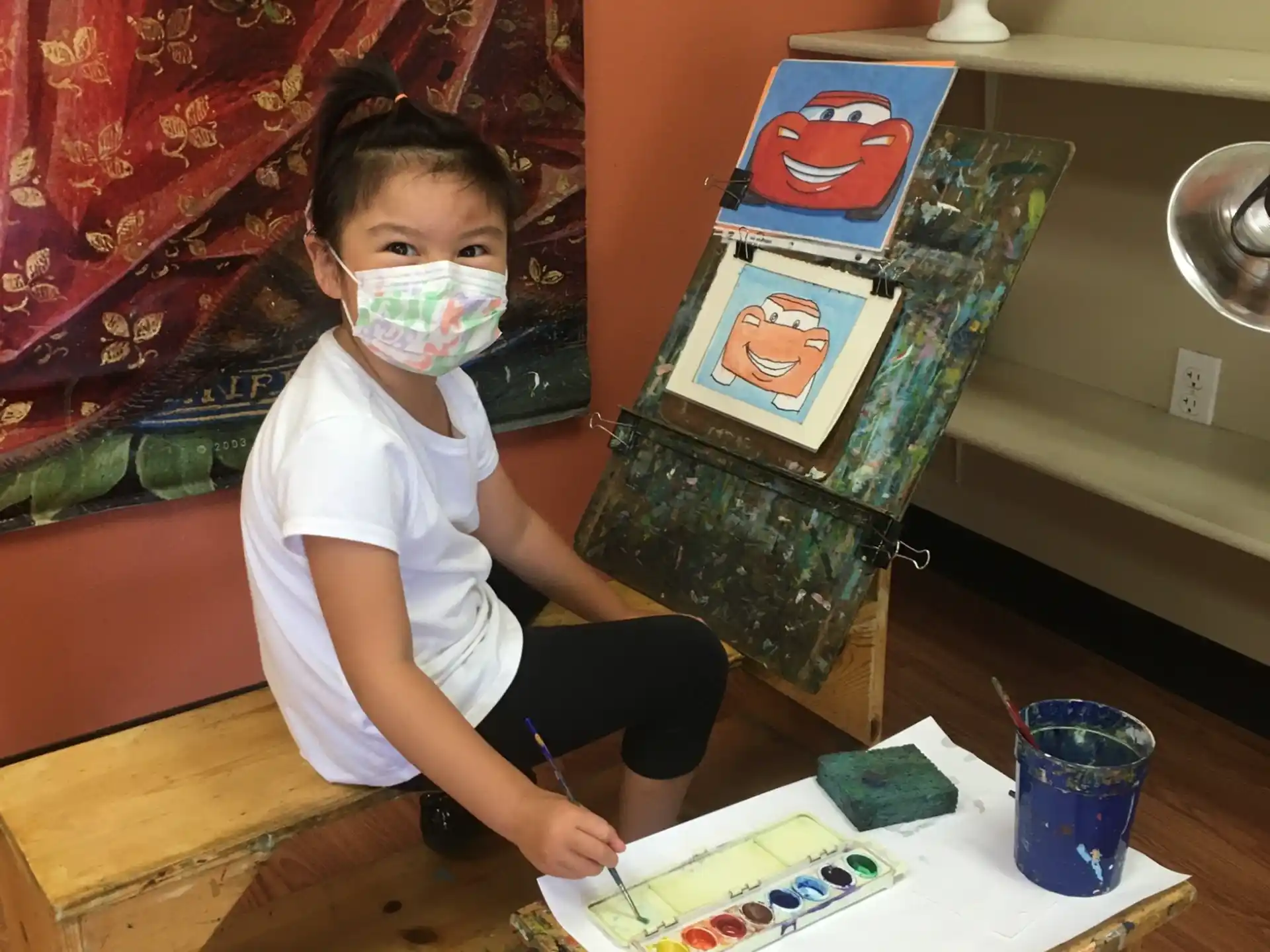 a child sitting on a bench with a mask on