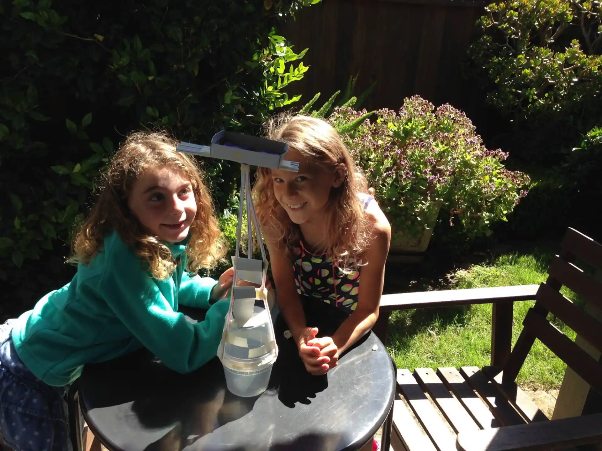 a couple of women sitting at a table outside