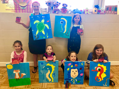 a group of children holding up colorful paper bags