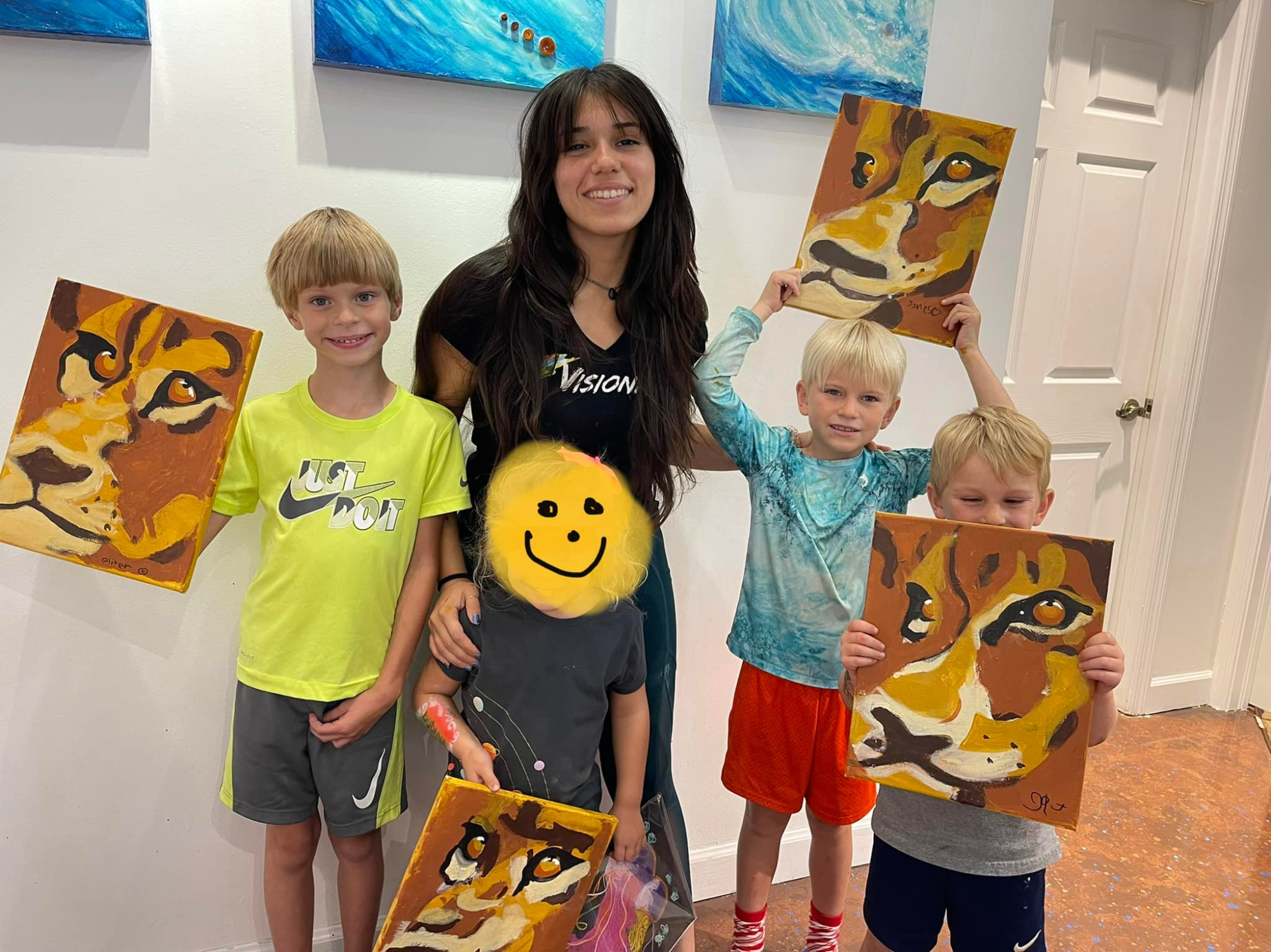 a person and several children holding up a yellow and black stuffed animal