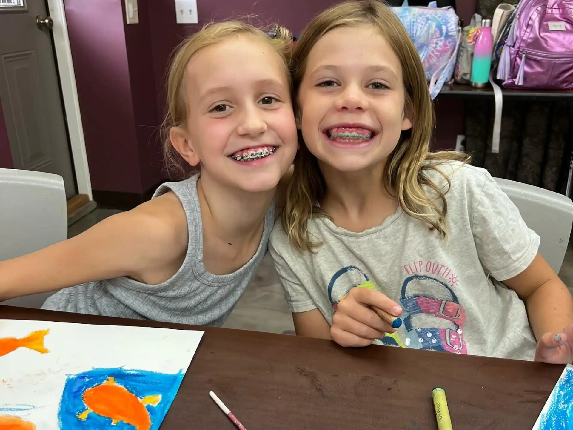 a couple of girls sitting at a table