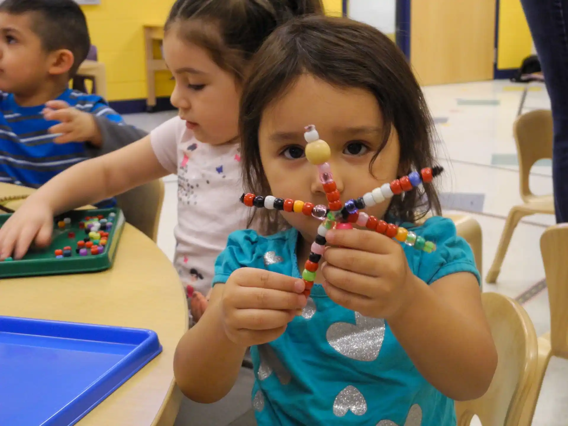 a young girl is holding a pair of scissors