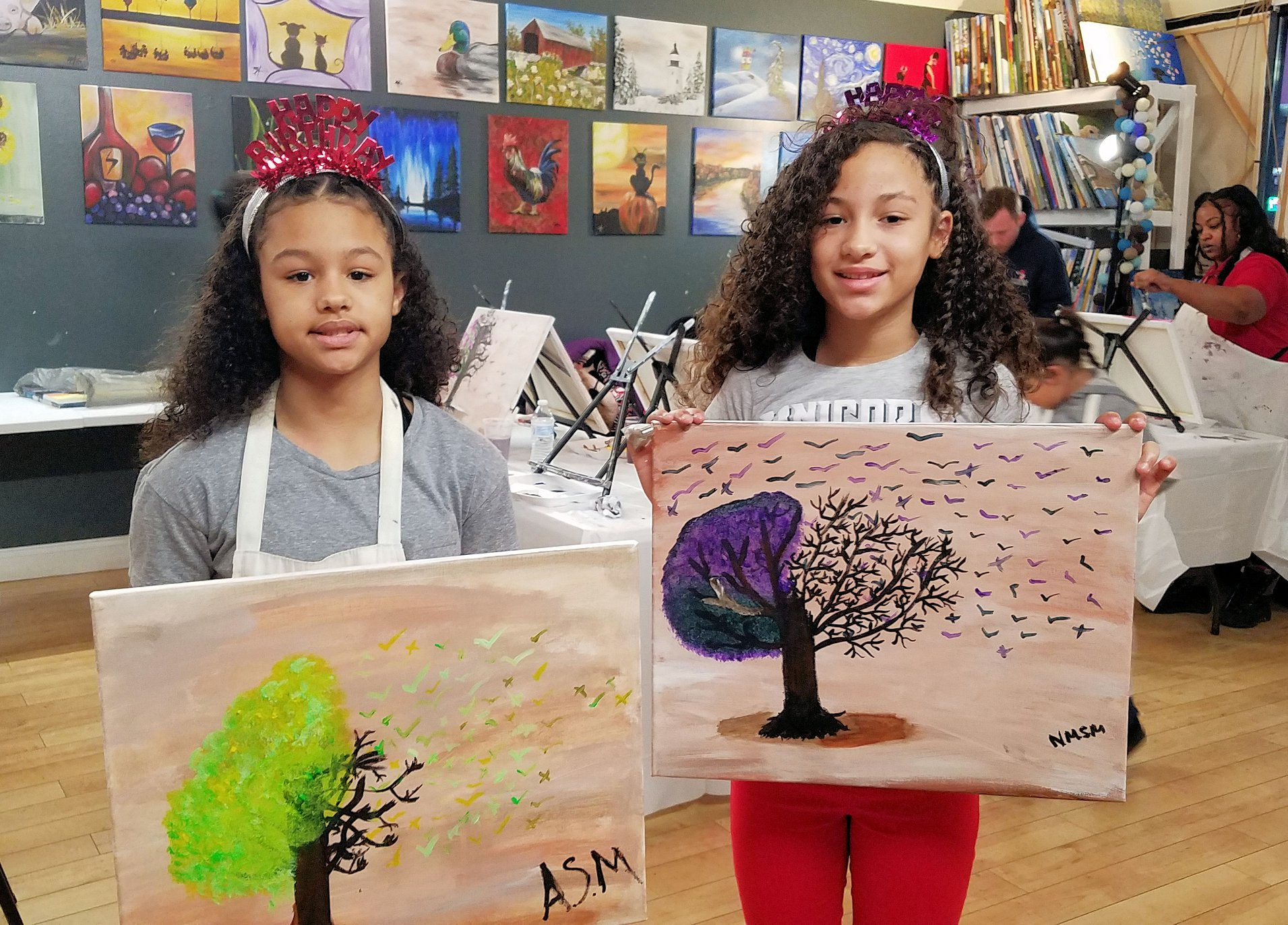a couple of girls holding a drawing