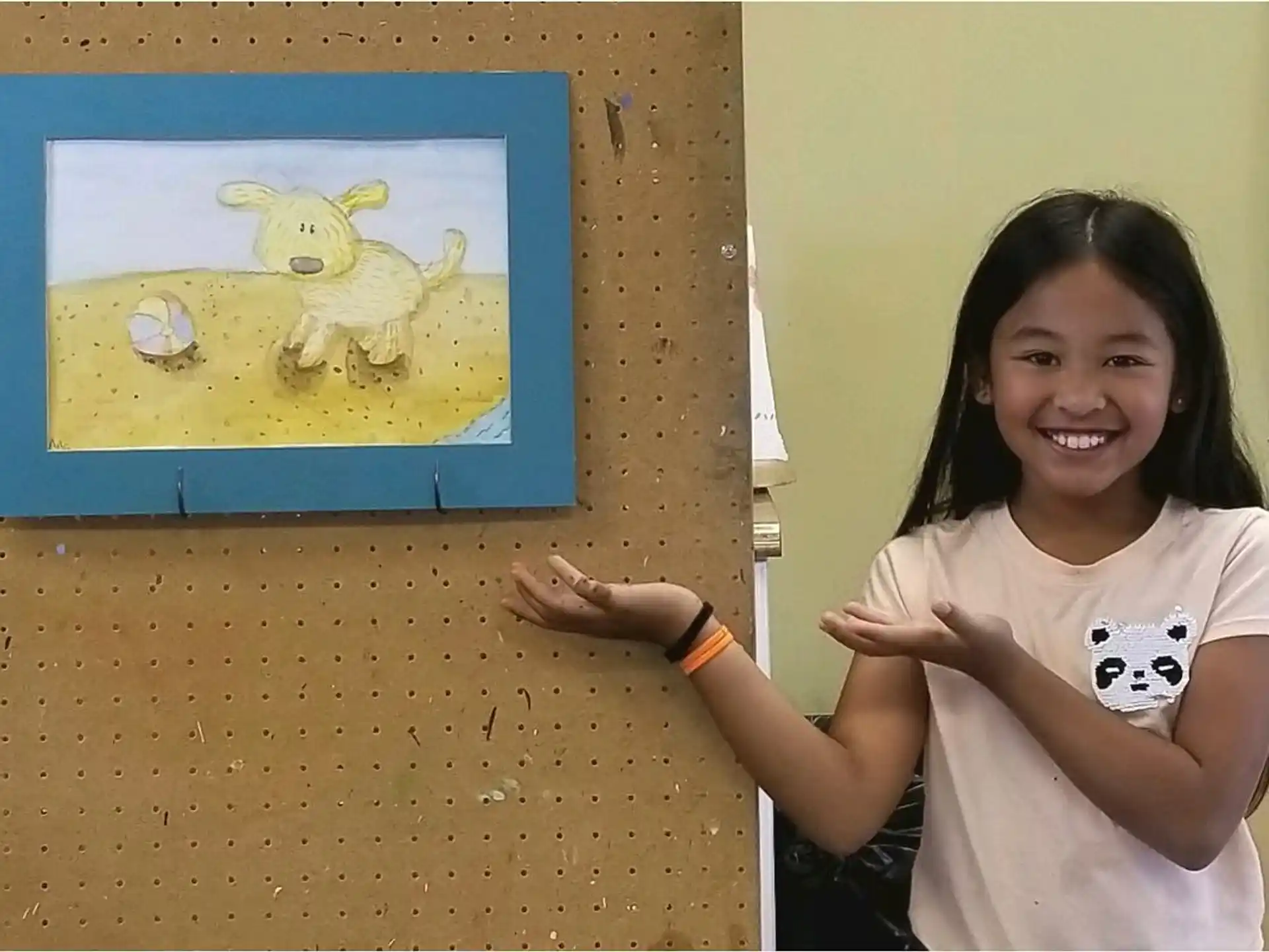 a girl smiling next to a painting