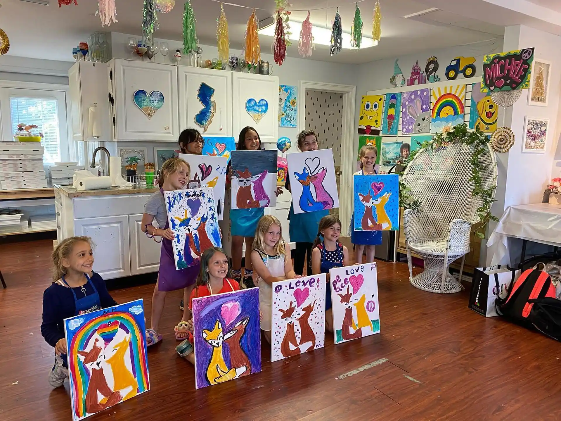 a group of children holding up colorful paper bags