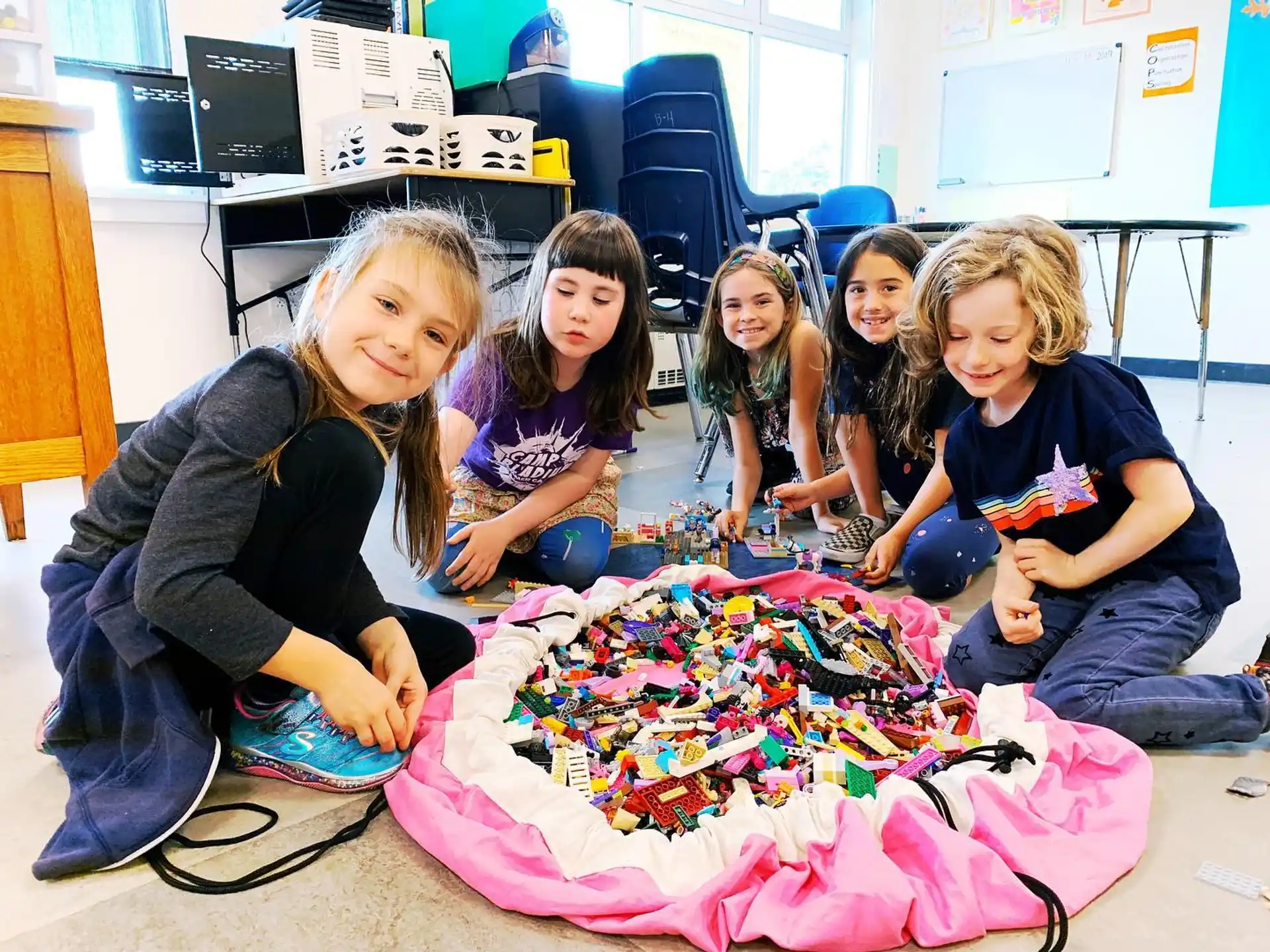 a group of girls sitting on the floor with a board game