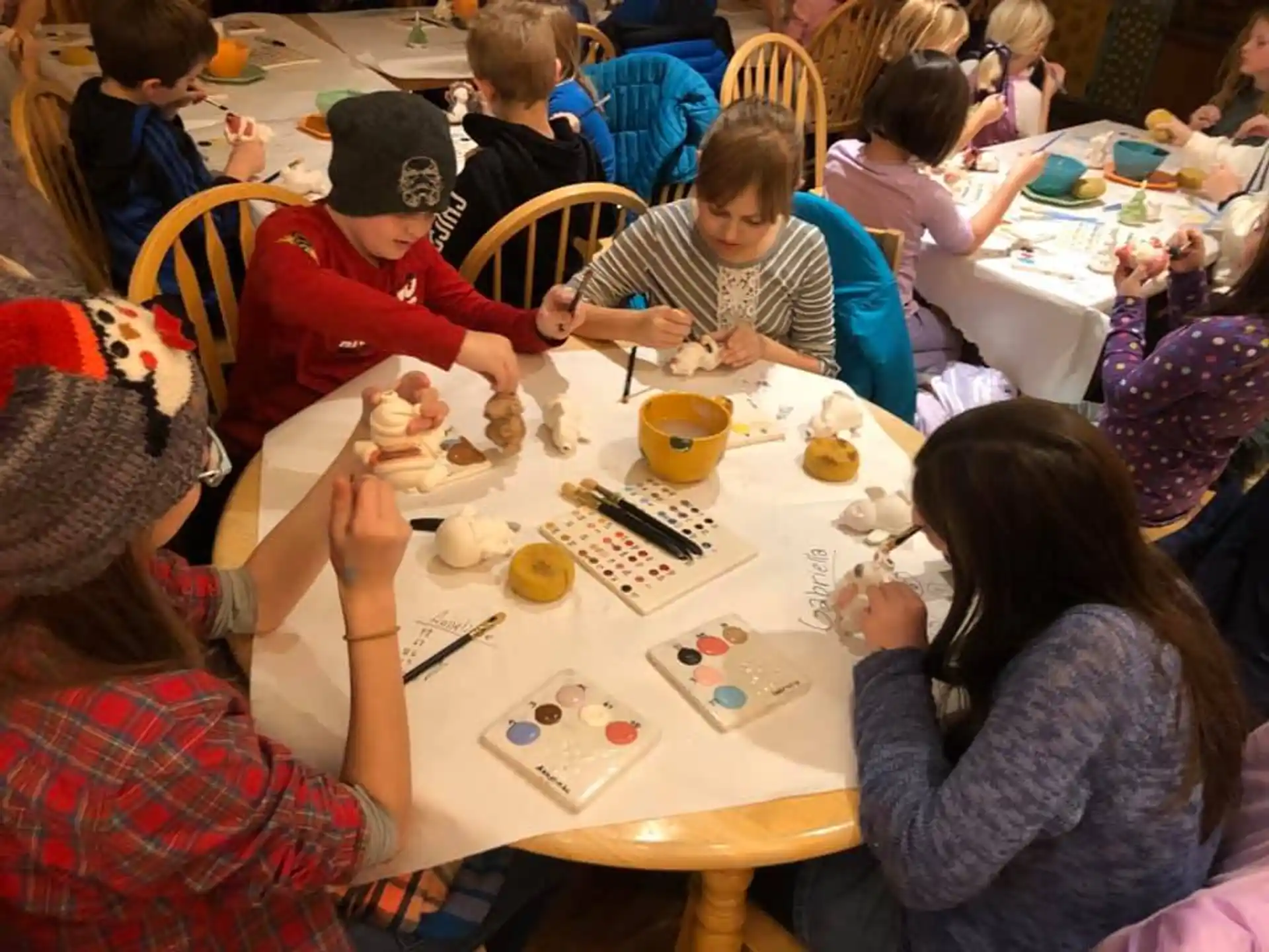 a group of children sitting around a table eating food