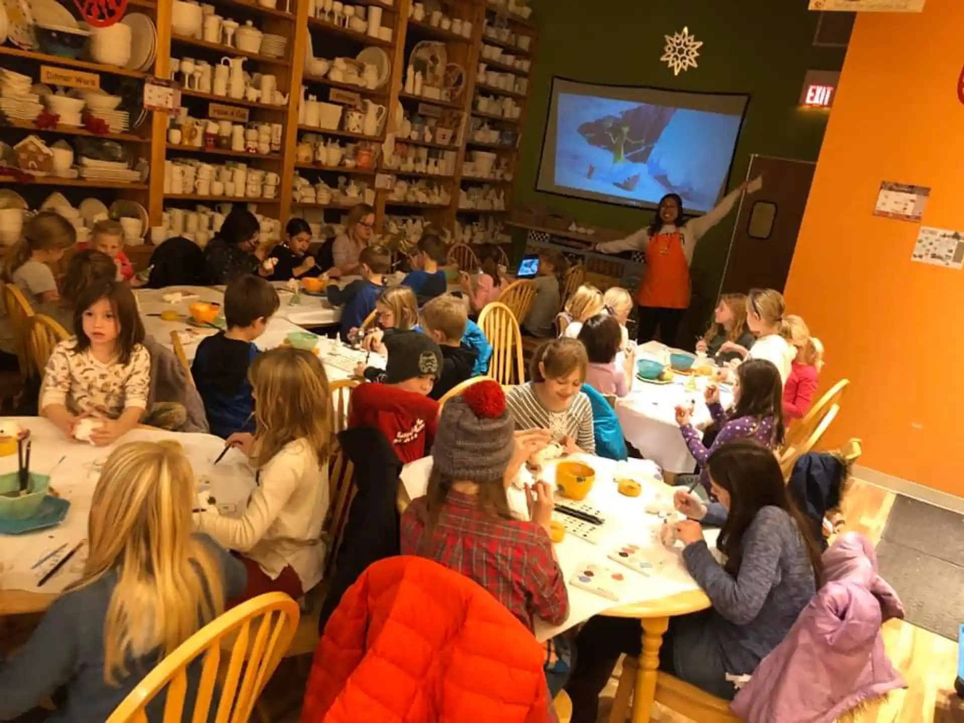 a group of people sitting at tables watching a television