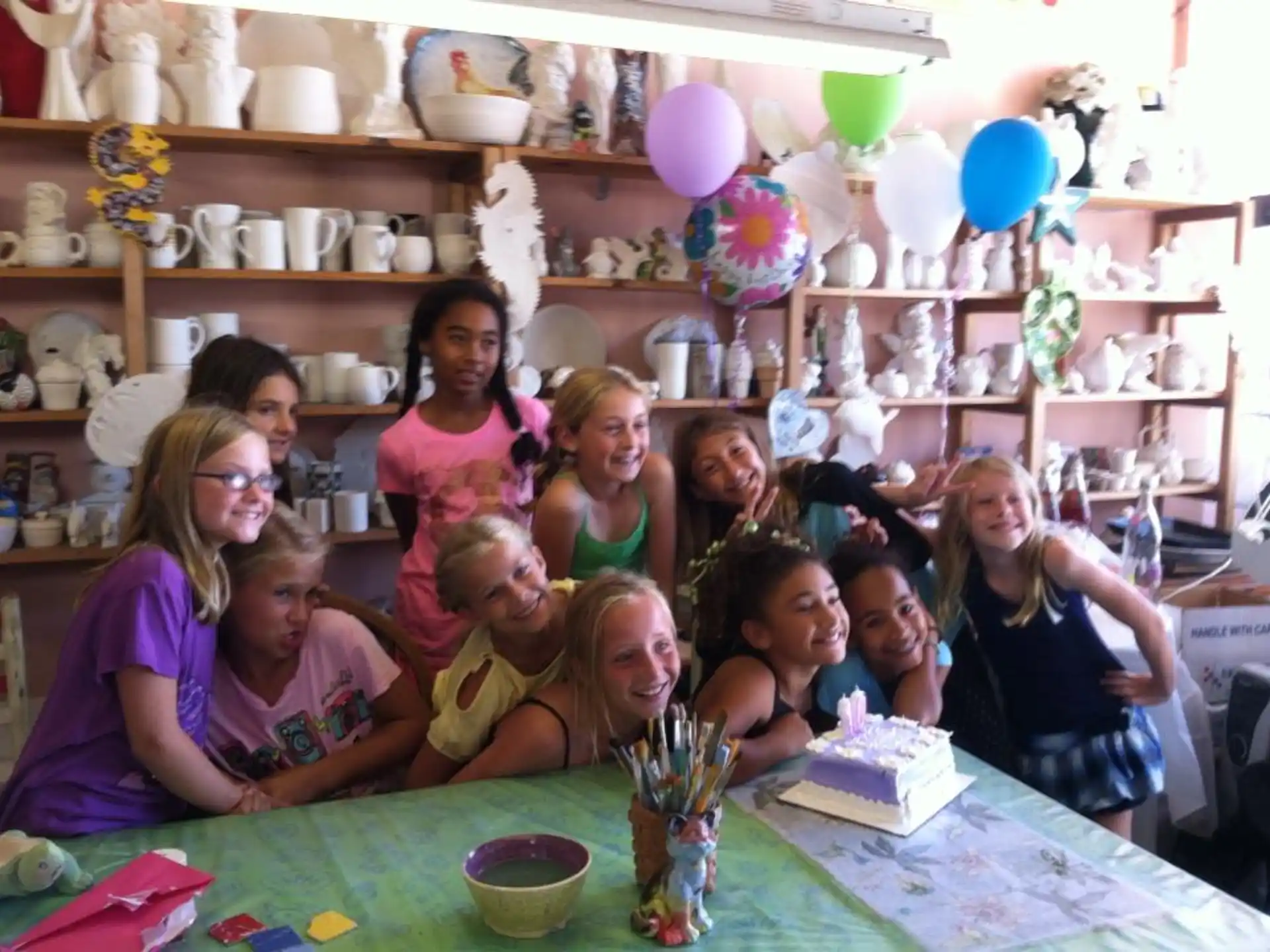 a group of people sitting at a table with a cake