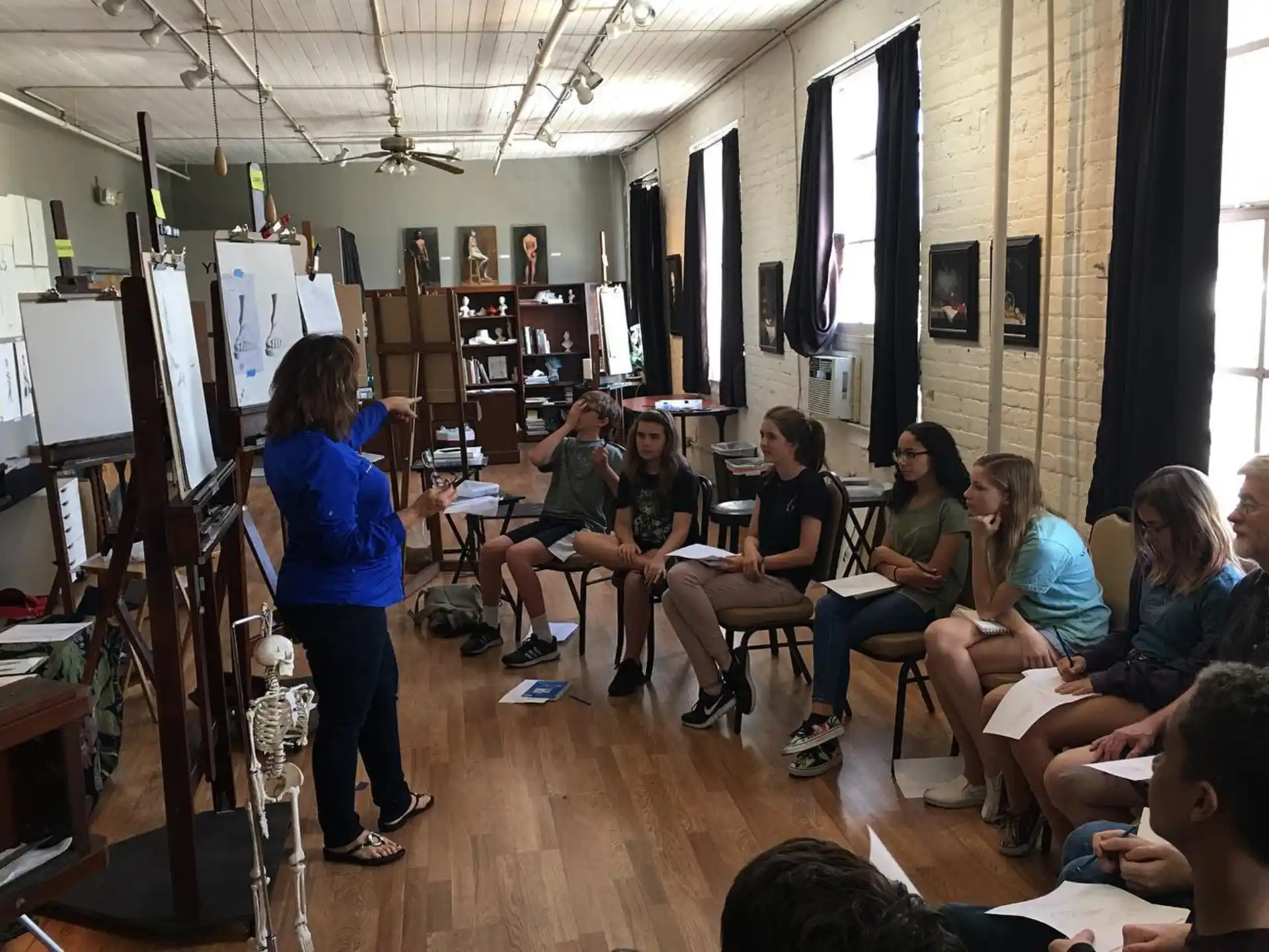 a person standing in front of a group of people sitting in a room