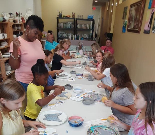 a person and a group of children eating at a table