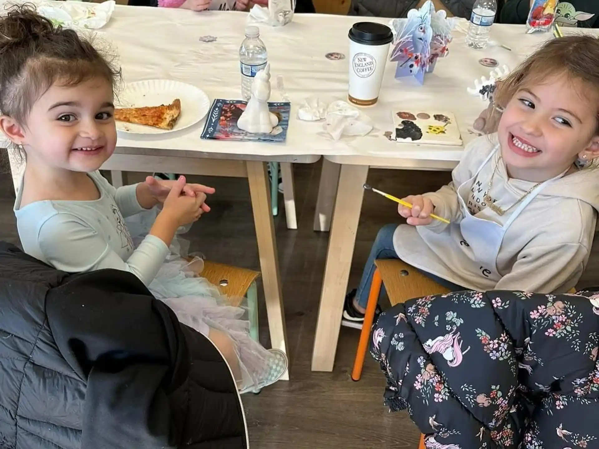 a group of children sitting at a table eating