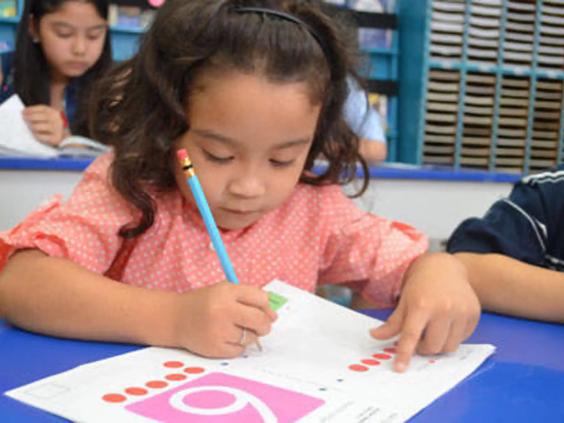 a young girl writing on a piece of paper
