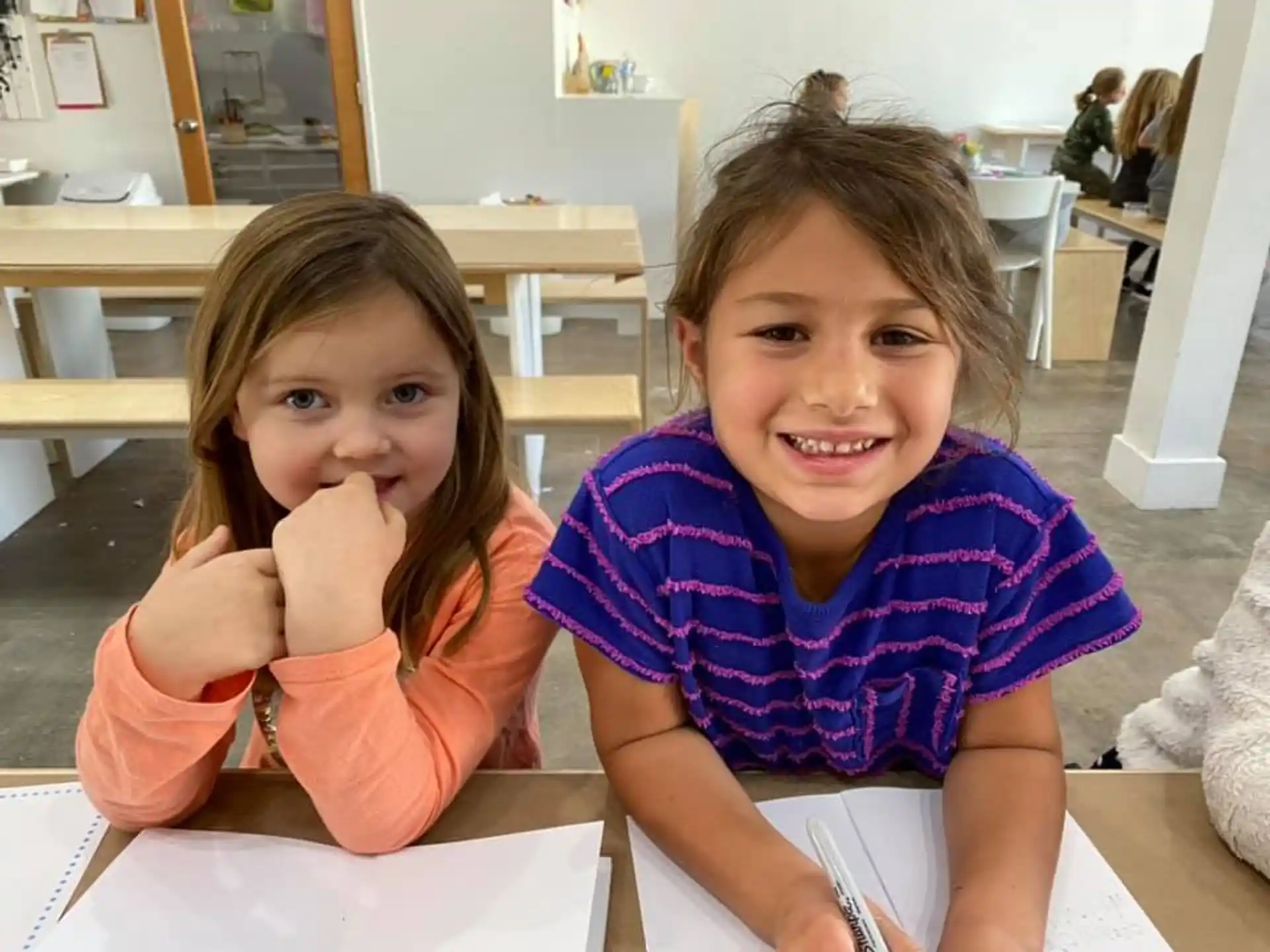 a couple of young girls sitting at a table