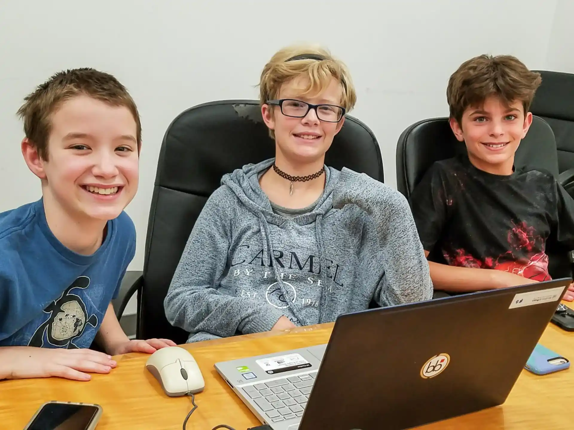 a group of people sitting at a table with a laptop