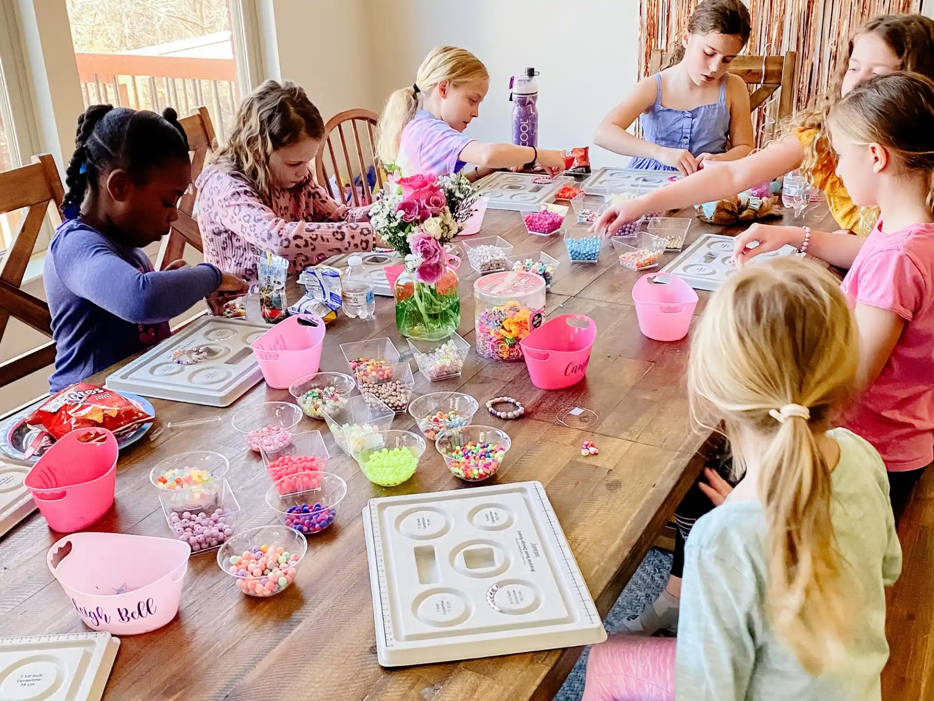 a group of children sitting around a table with colorful cups