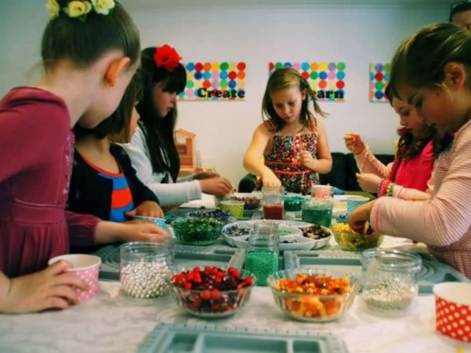a group of girls sitting at a table with food