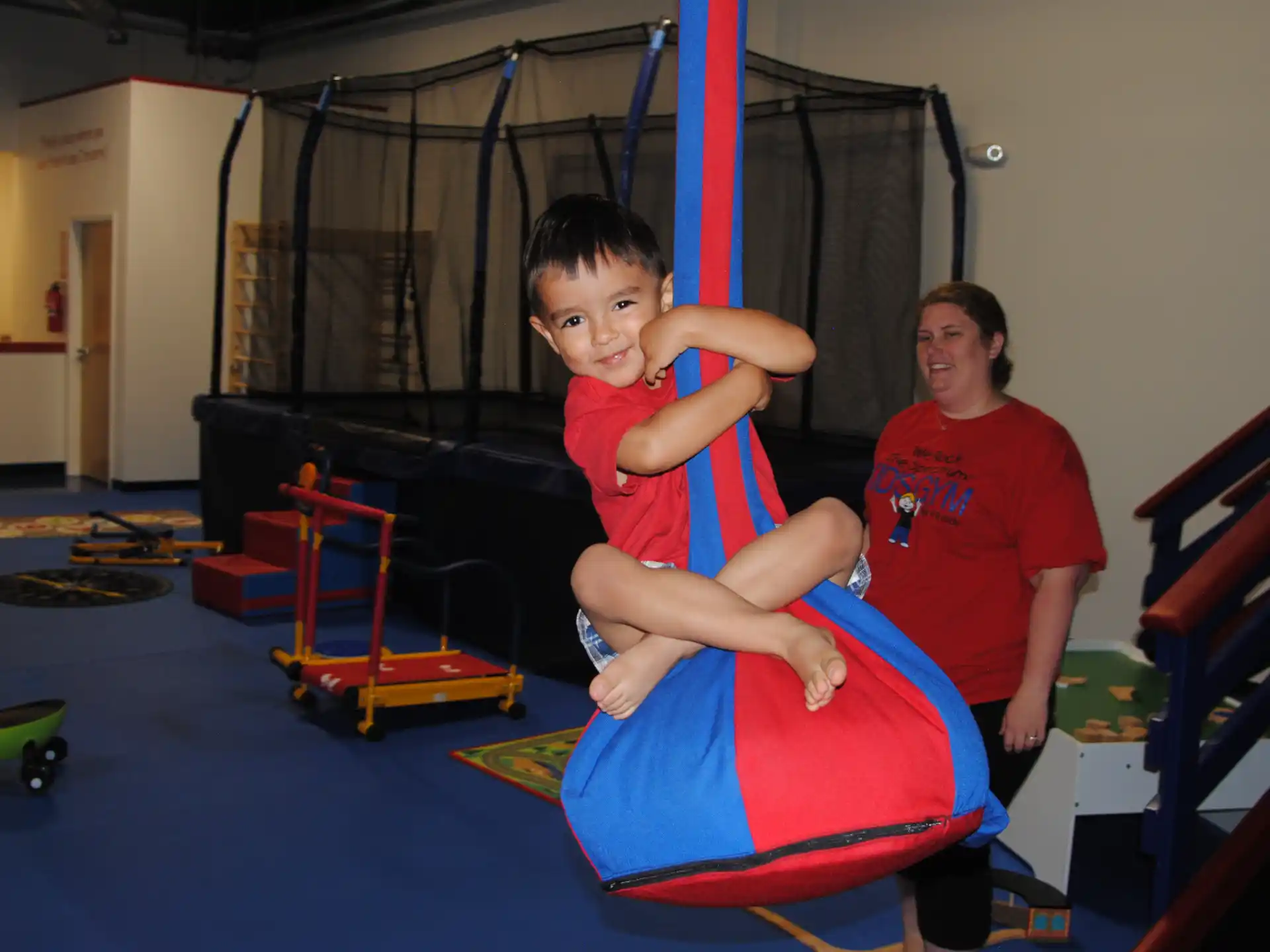 a person and a boy on a slide in a room