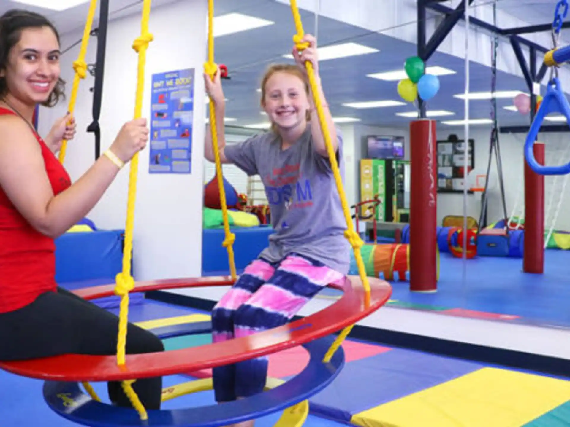 a person and a girl on a swing set