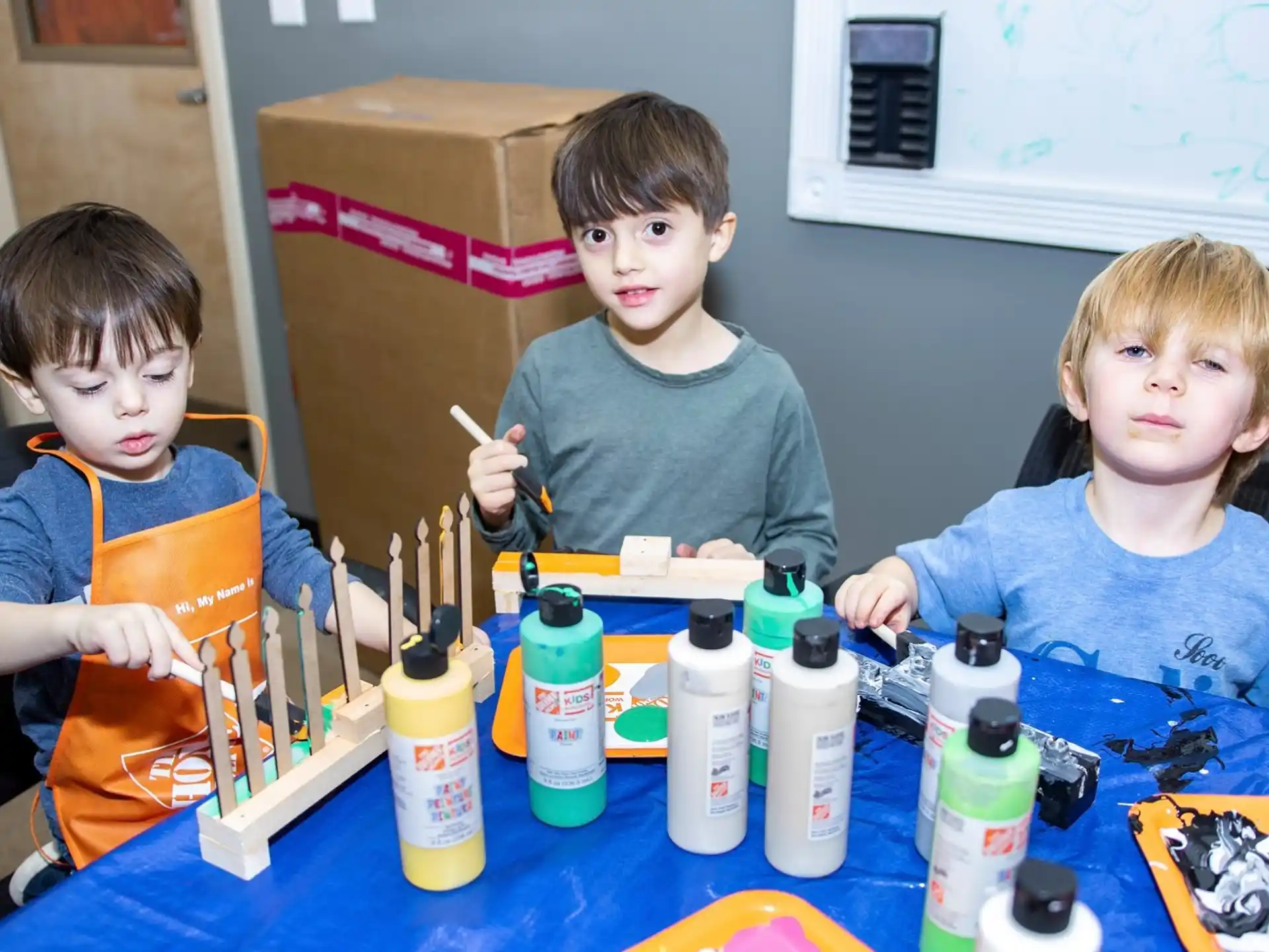 a group of boys sitting at a table with bottles of liquid
