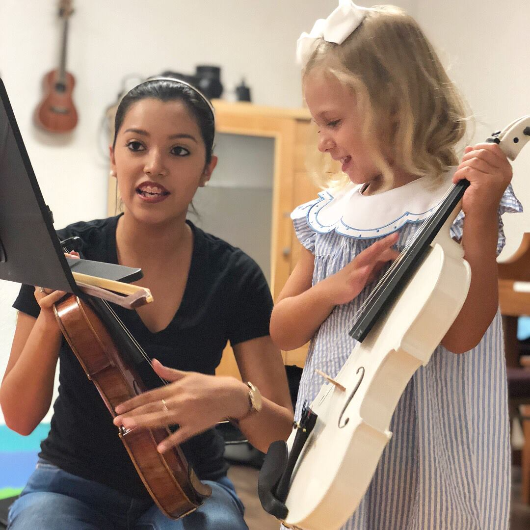 a person holding a guitar next to a person holding a guitar