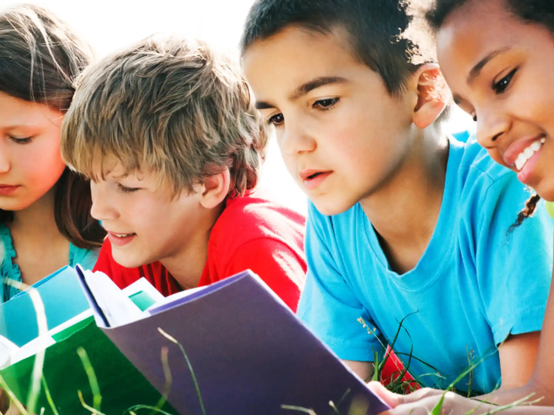 a group of children looking at a book