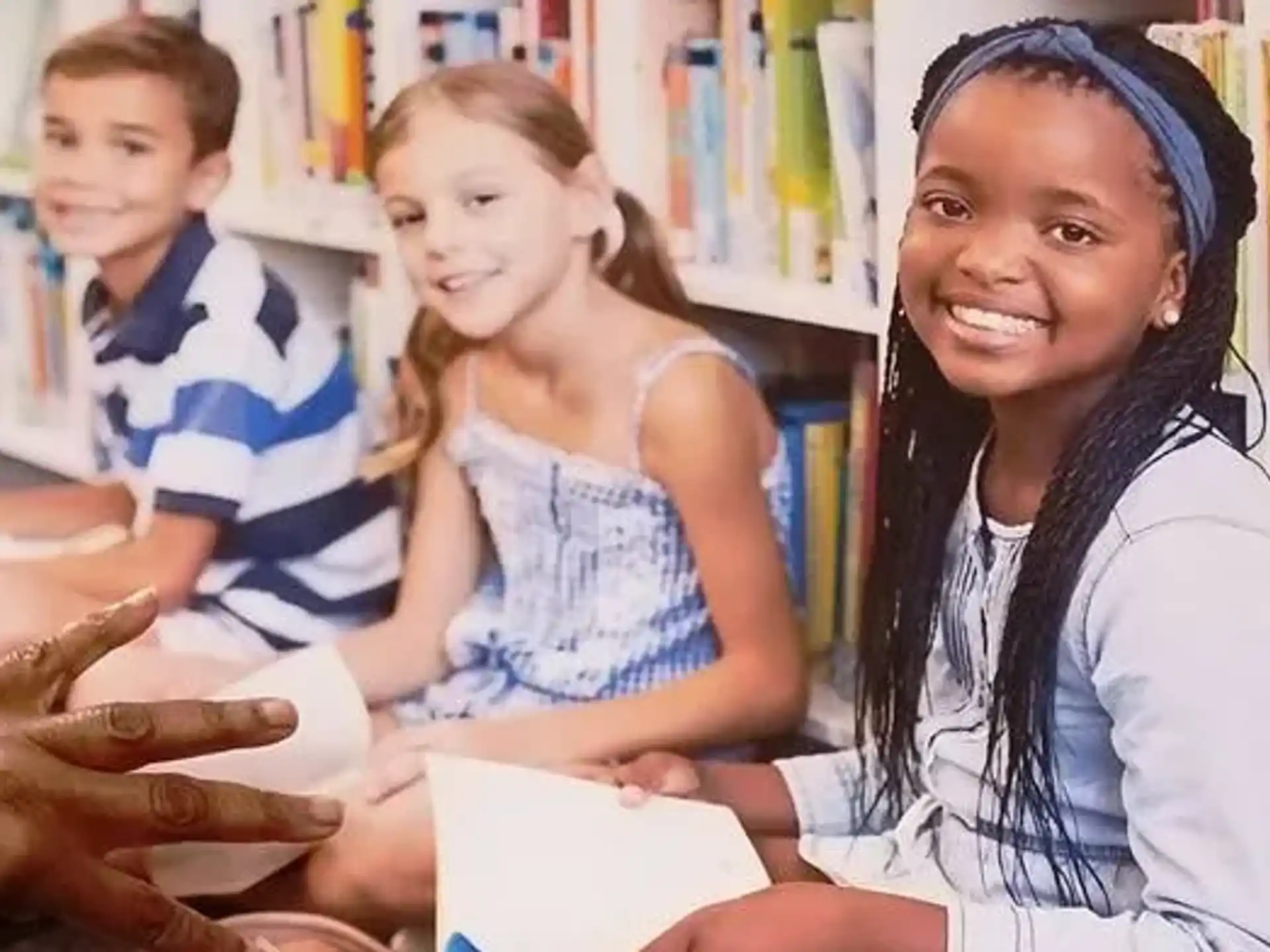 a person and a few children in a library