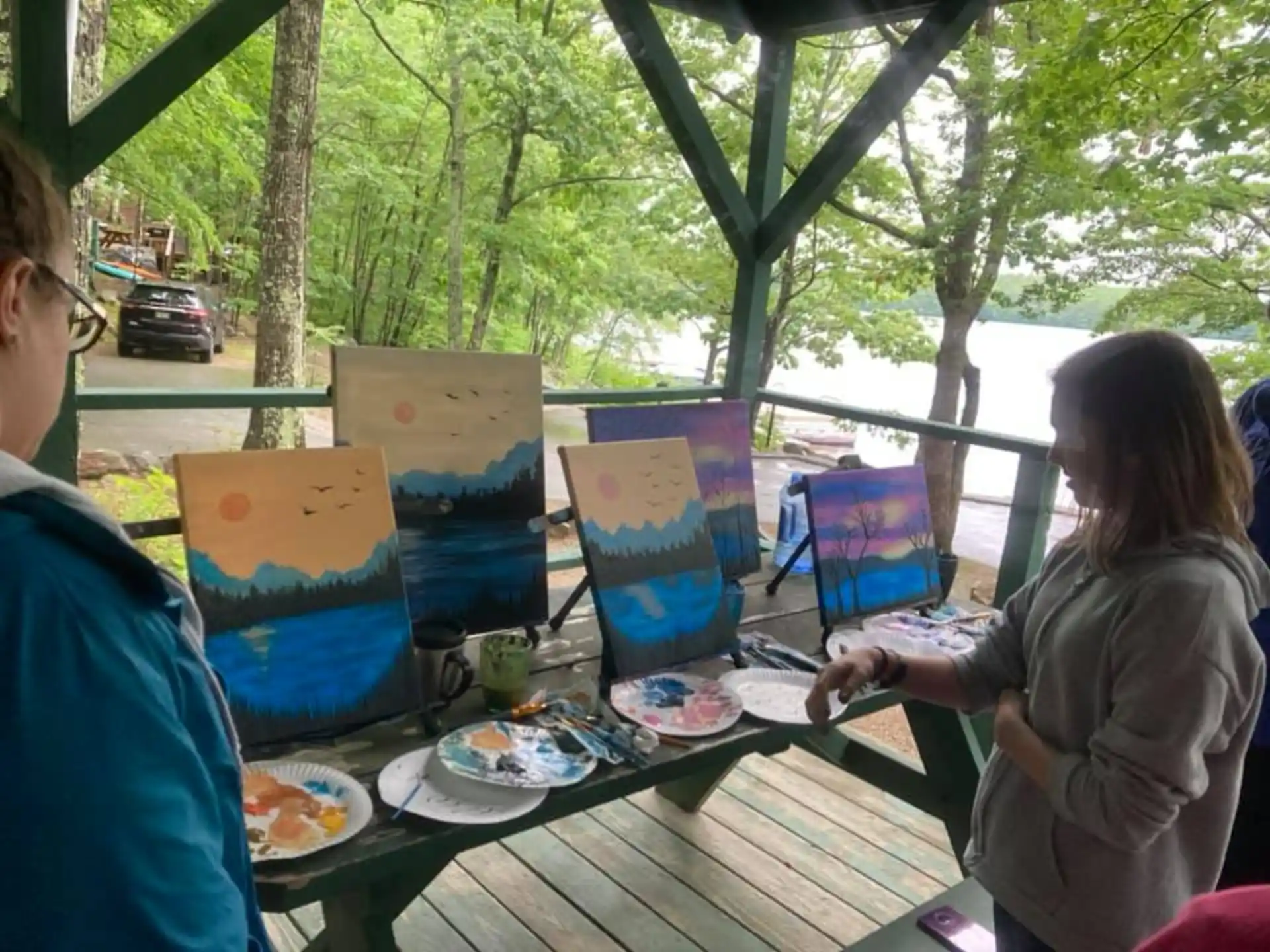 a couple of people sitting at a picnic table with food and drinks