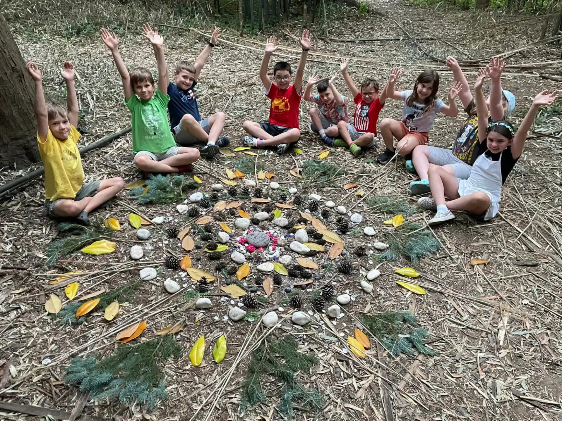 a group of people sitting on the ground with their arms raised