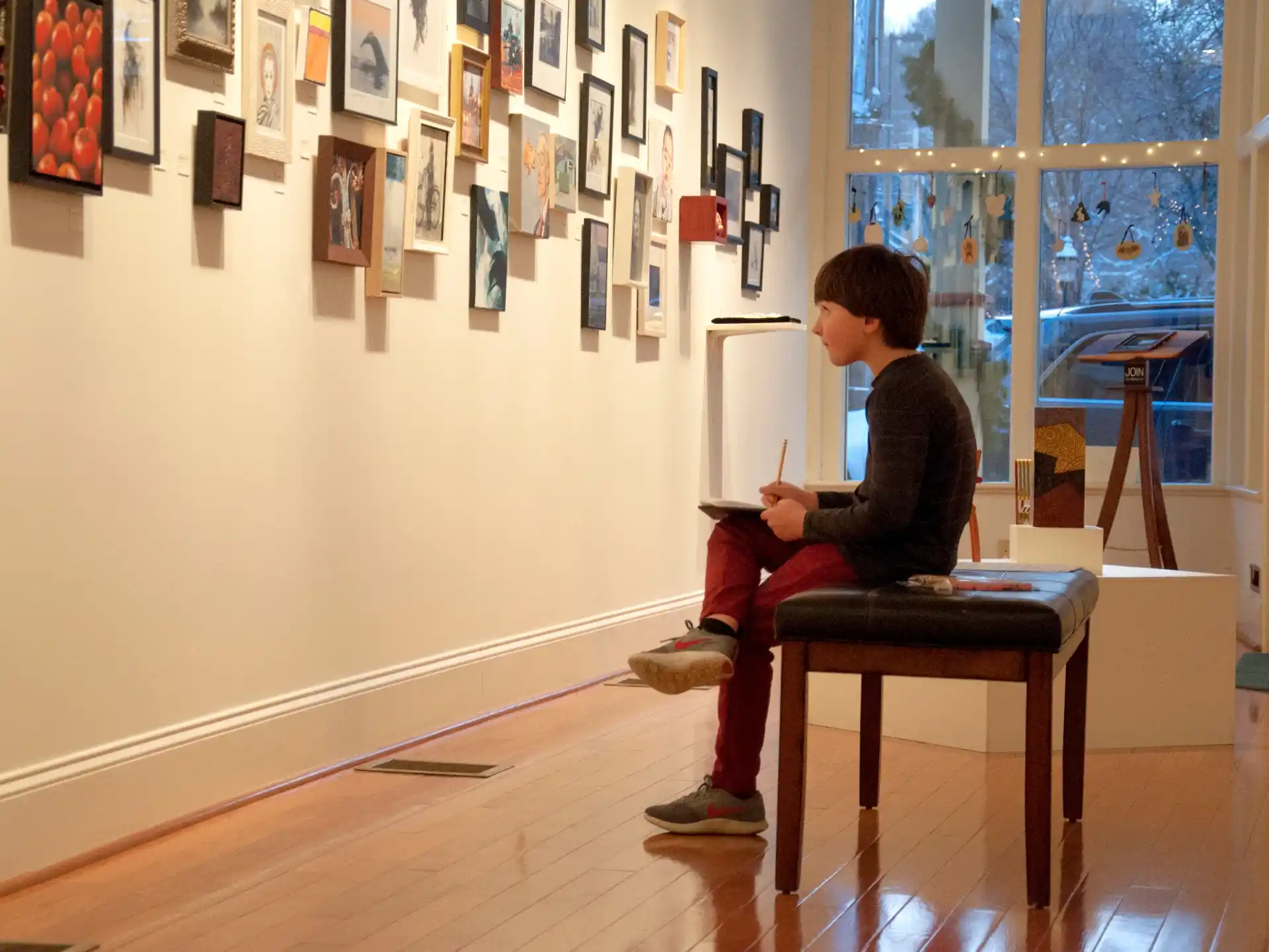 a person sitting on a chair in a room with pictures on the wall