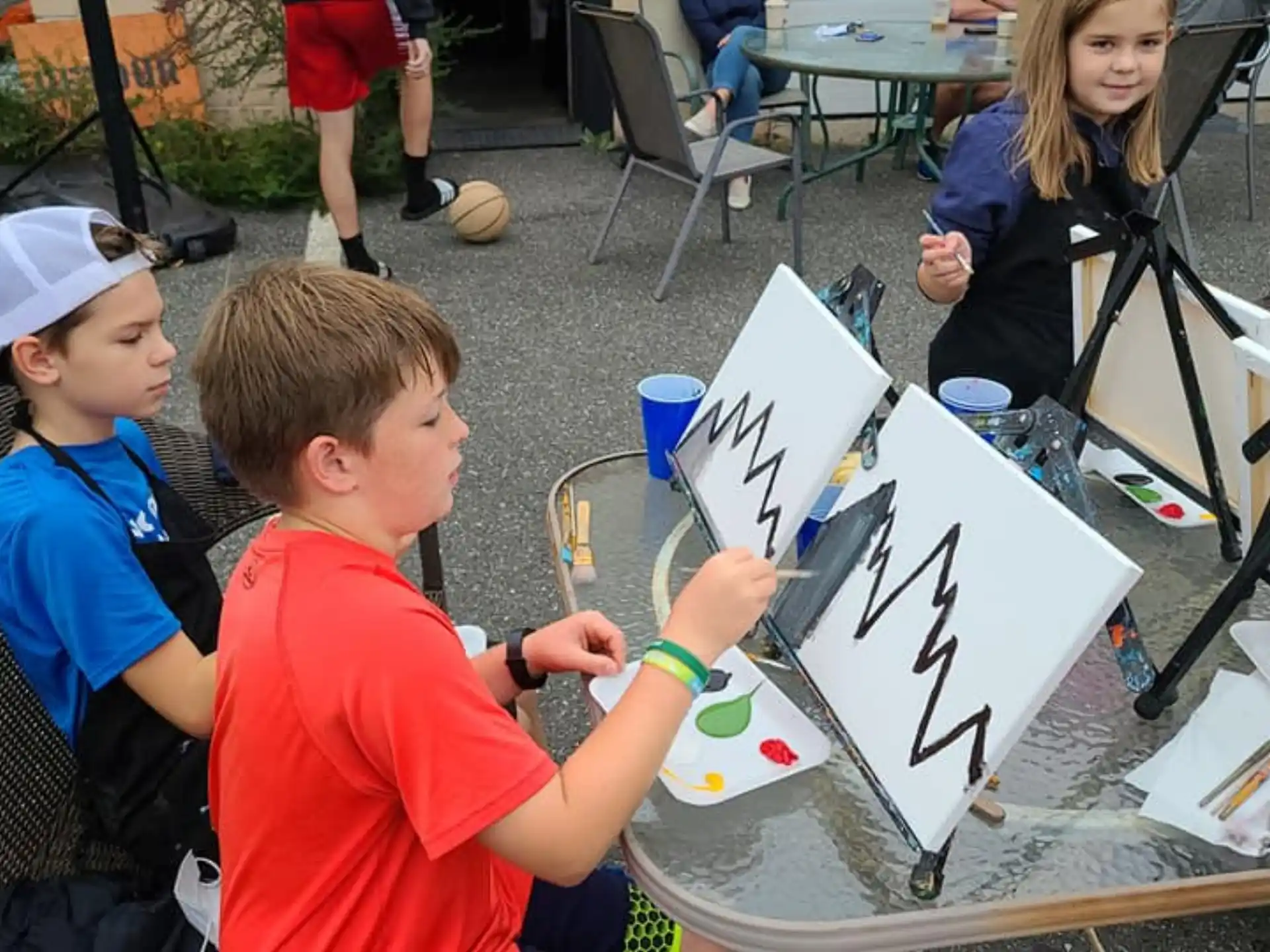 a group of children sitting at a table with a drawing