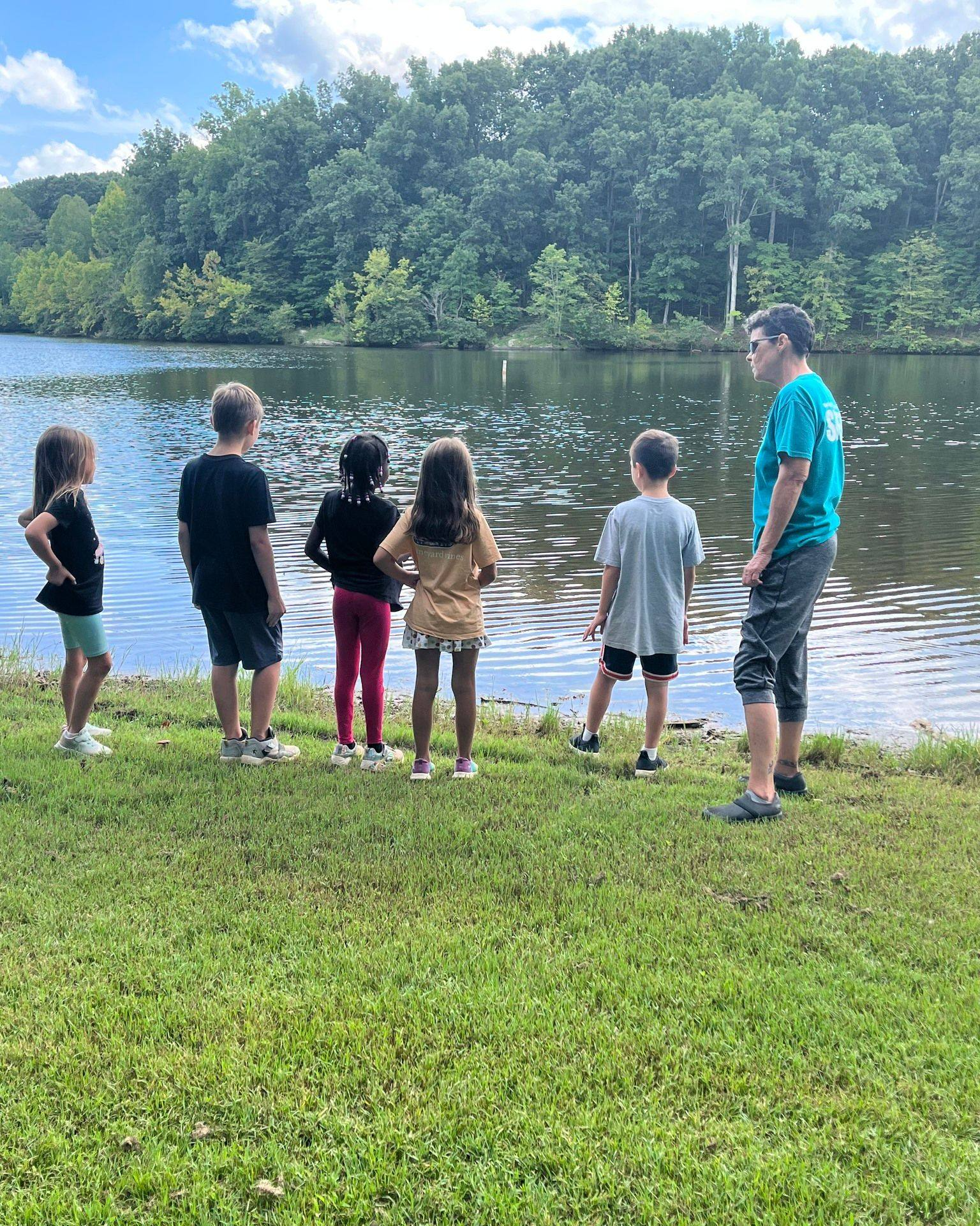 a group of people standing by a lake