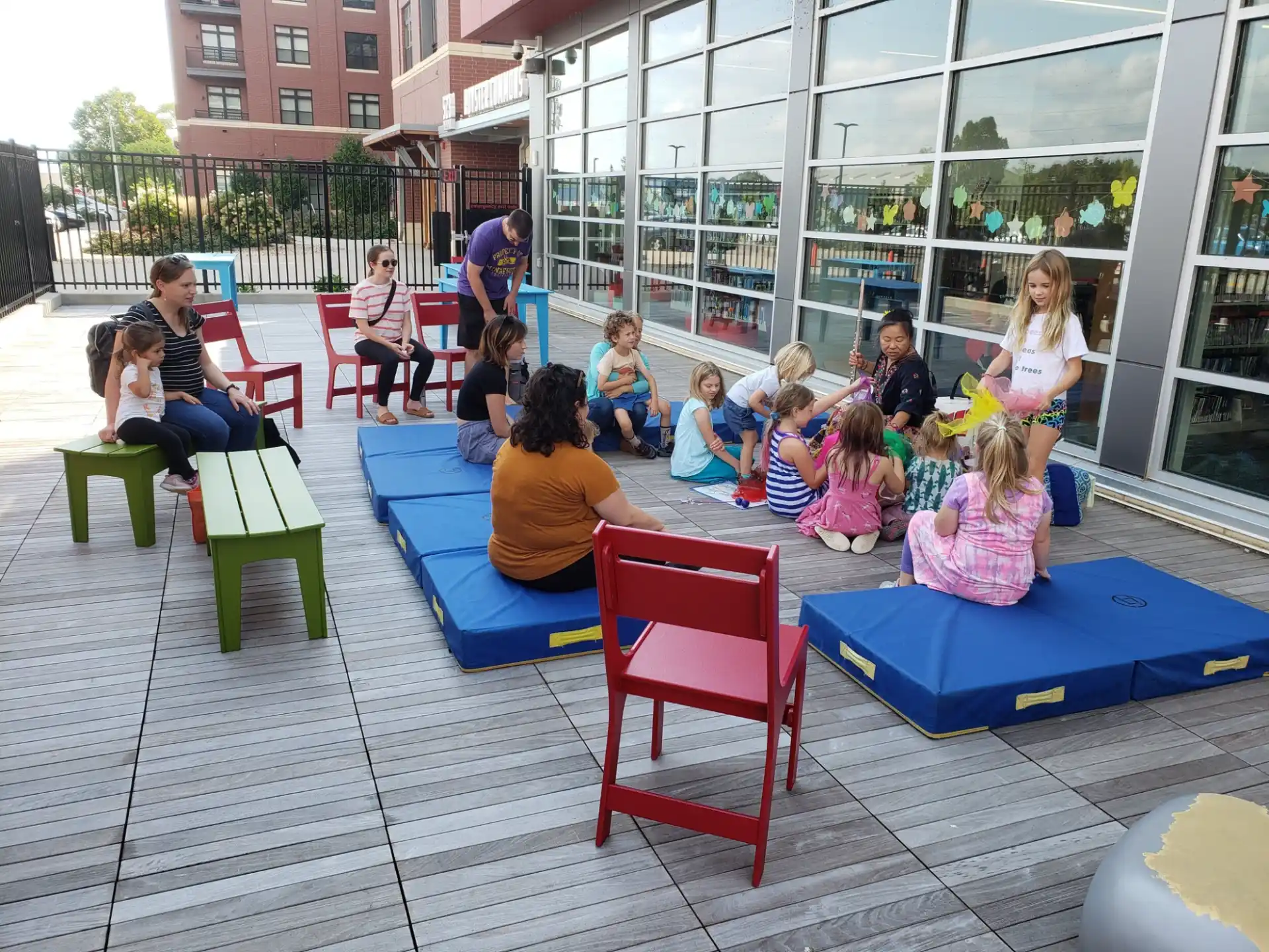 a group of people sitting on blue benches outside a building