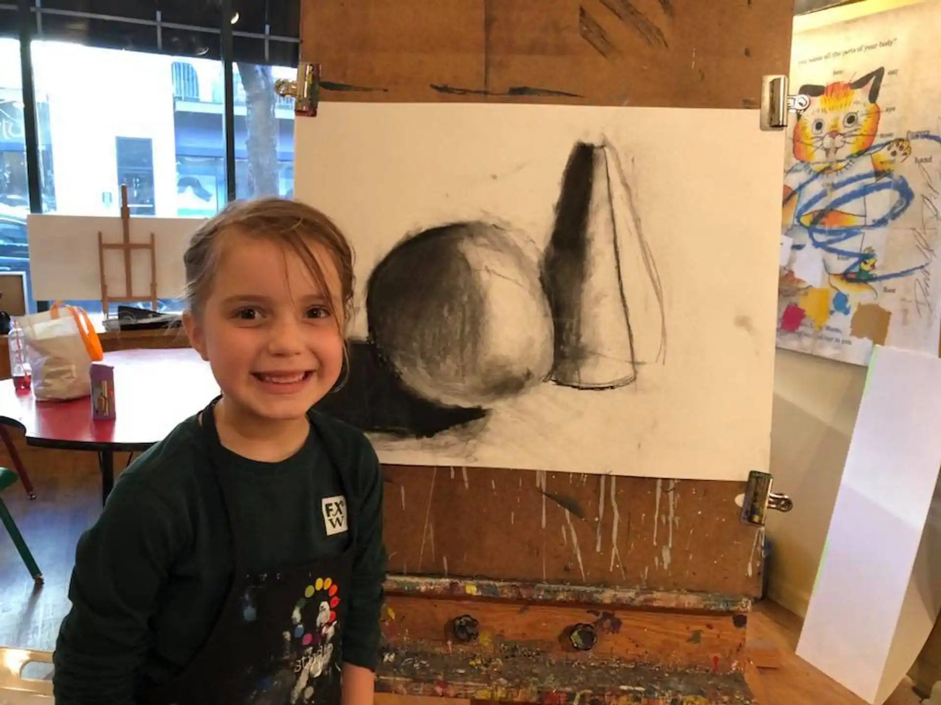 a child standing in front of a painting
