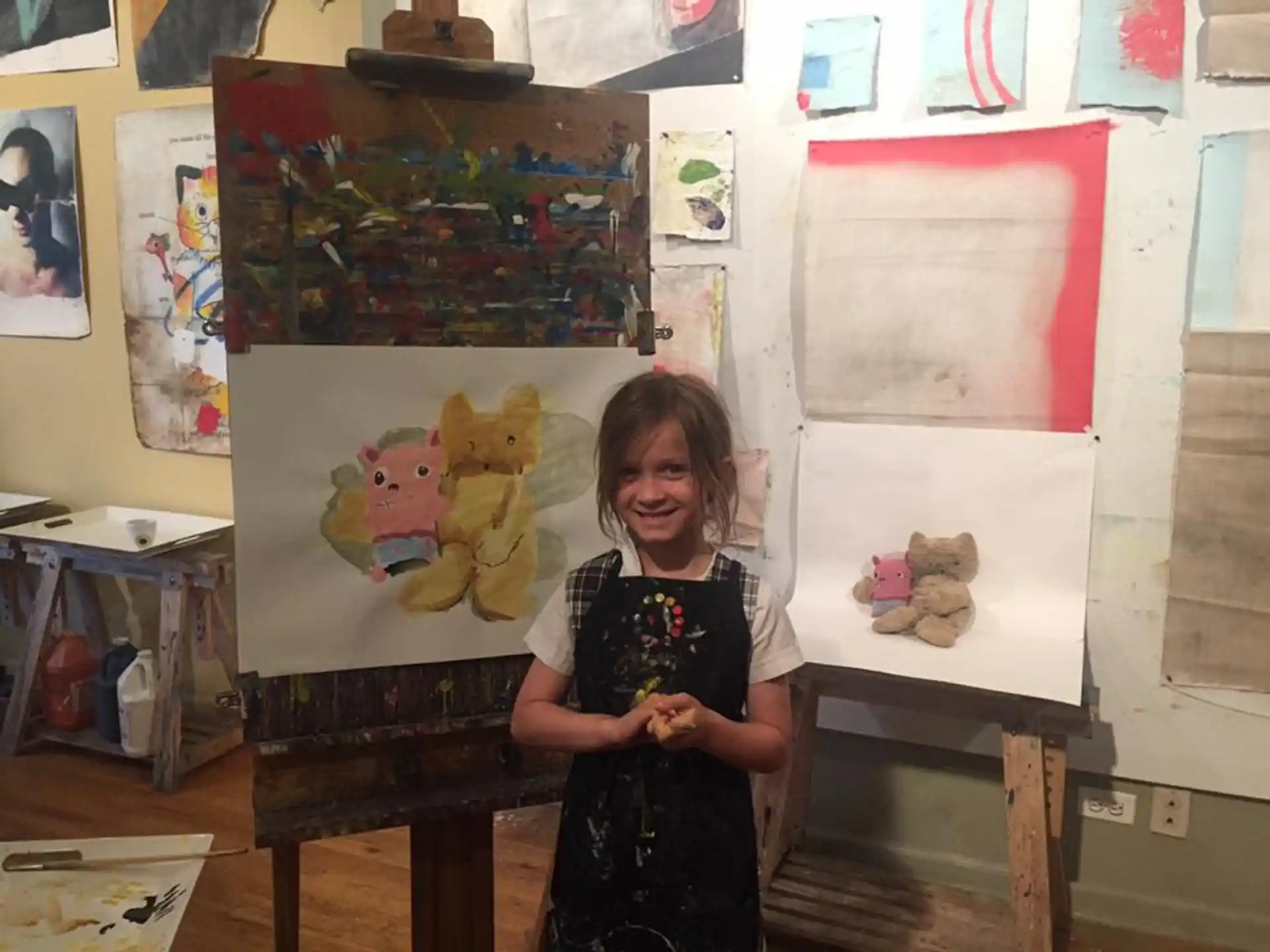 a girl standing in a room with art on the wall