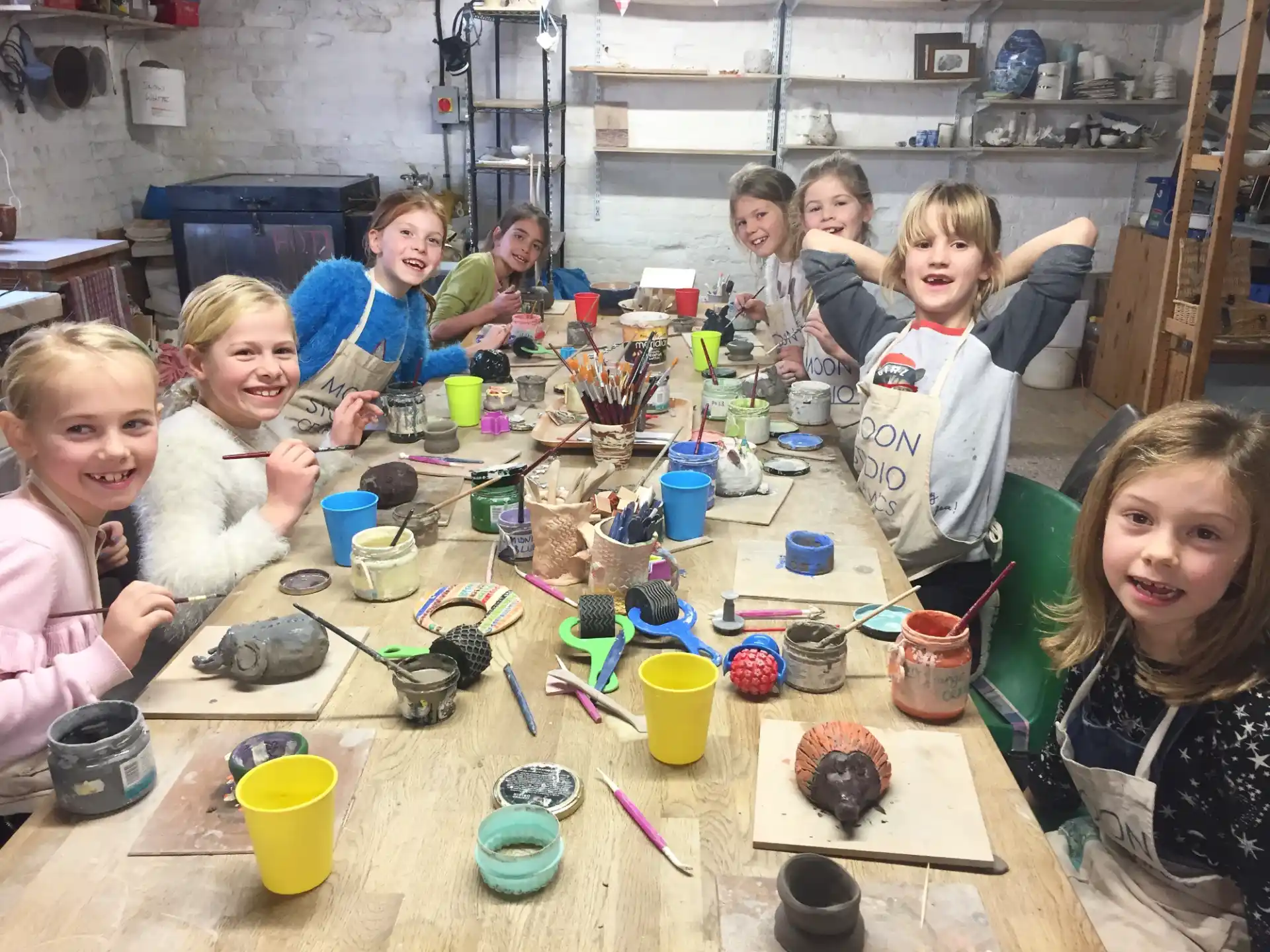 a group of children sitting at a table with a cake