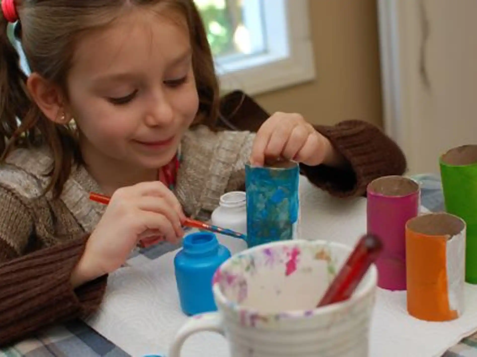 a girl painting a cup