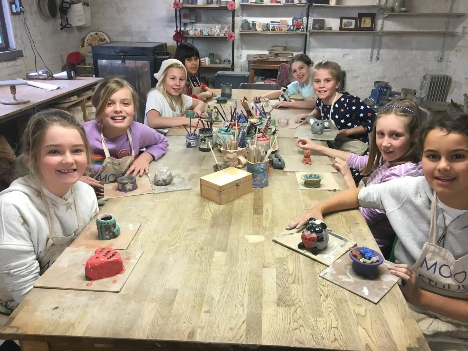 a group of children sitting at a table with toys