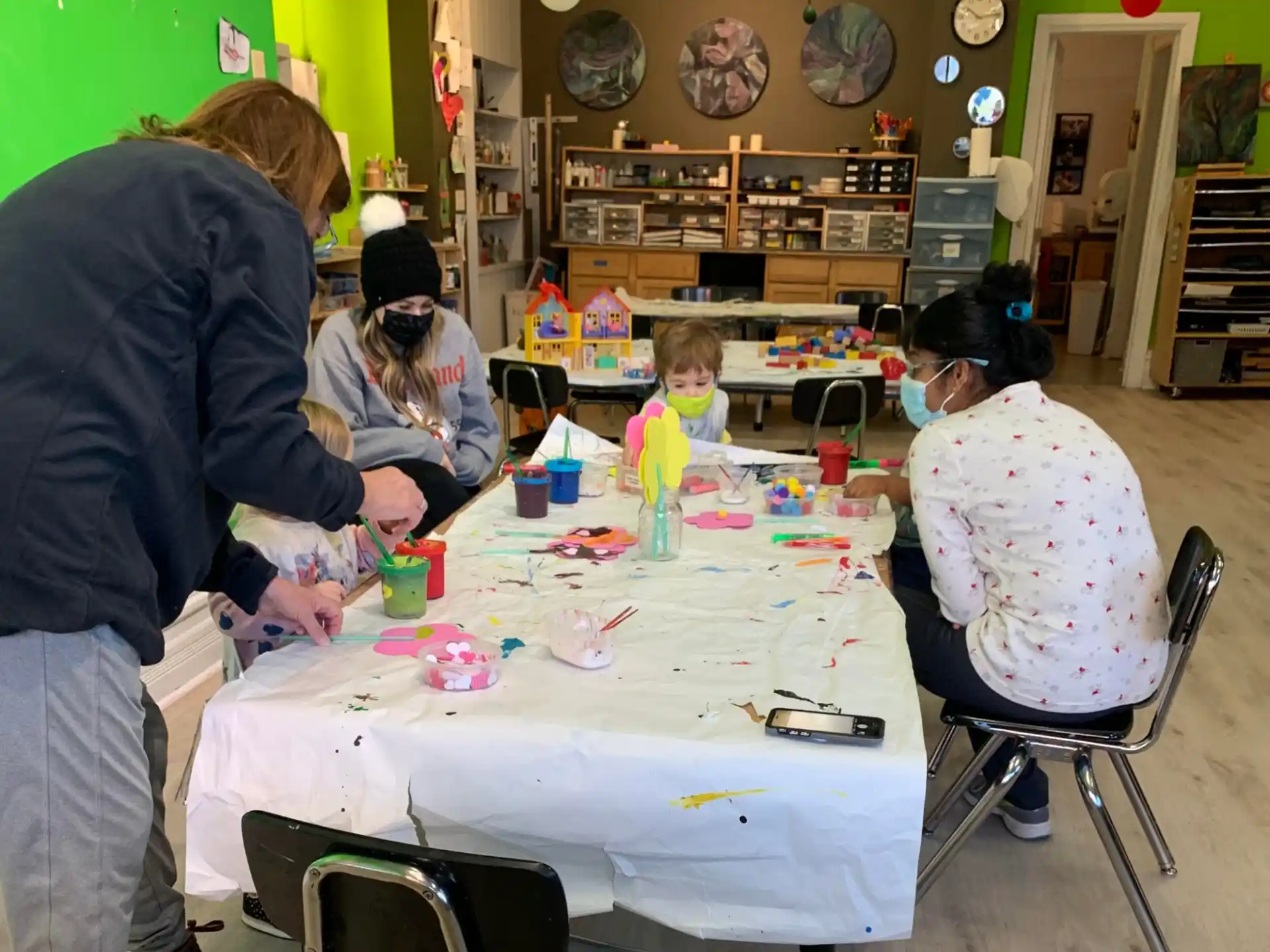 a group of people sitting around a table with toys