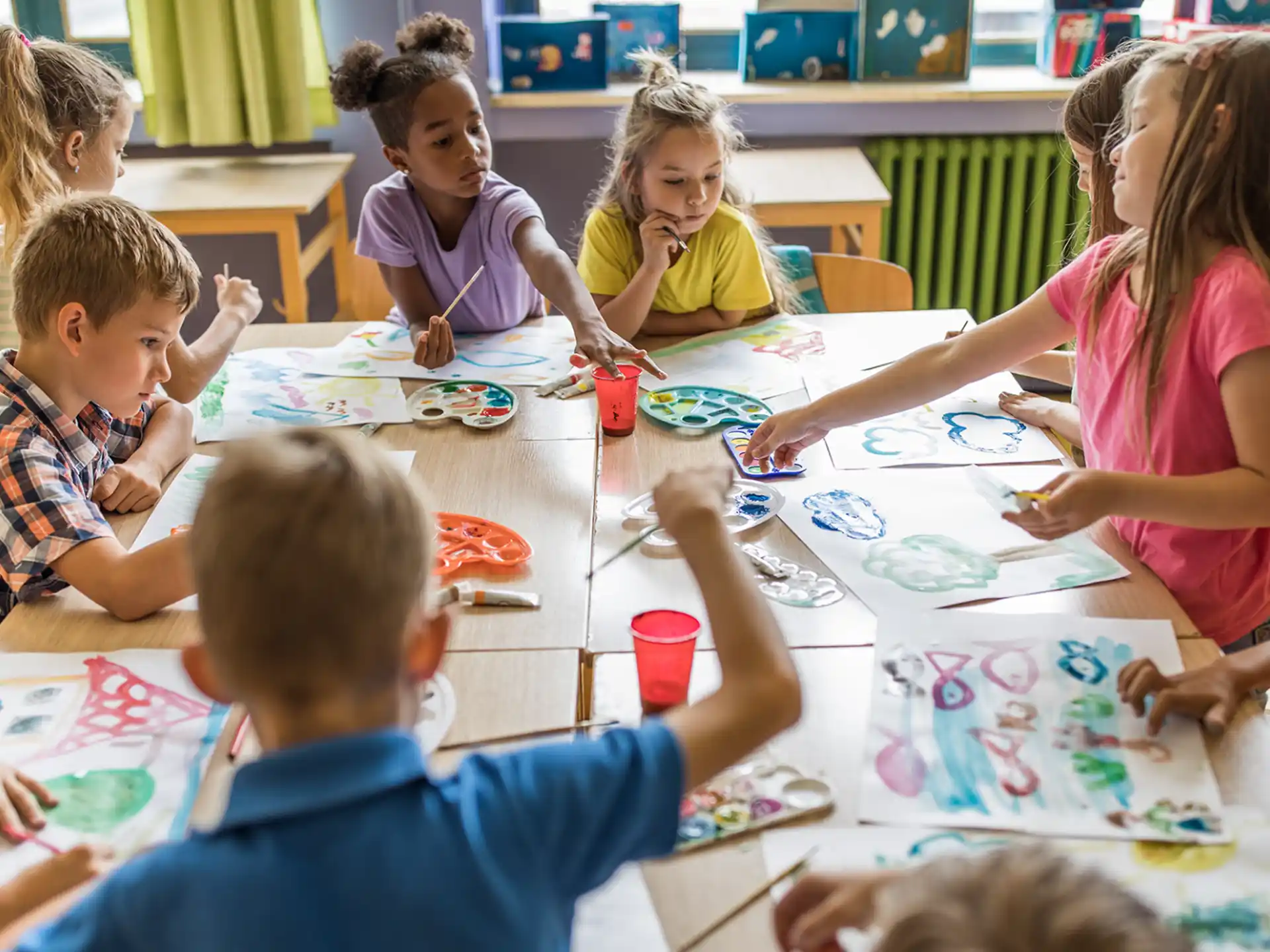 a group of children sitting around a table