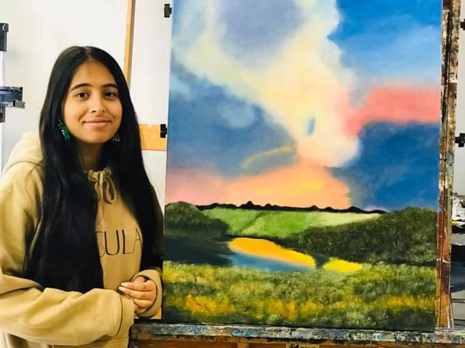 a woman standing next to a painting