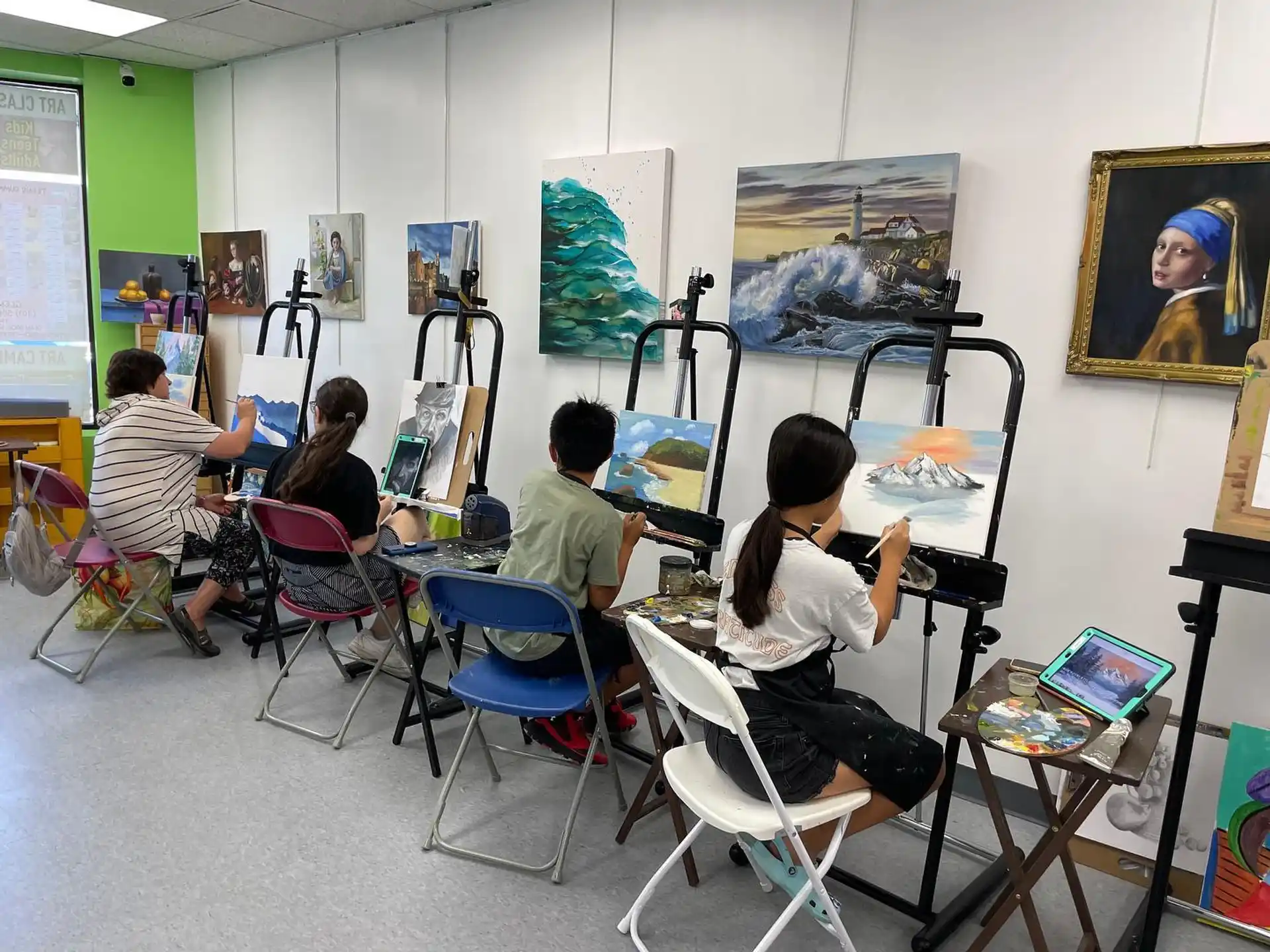 a group of people sitting in a room with art on the walls