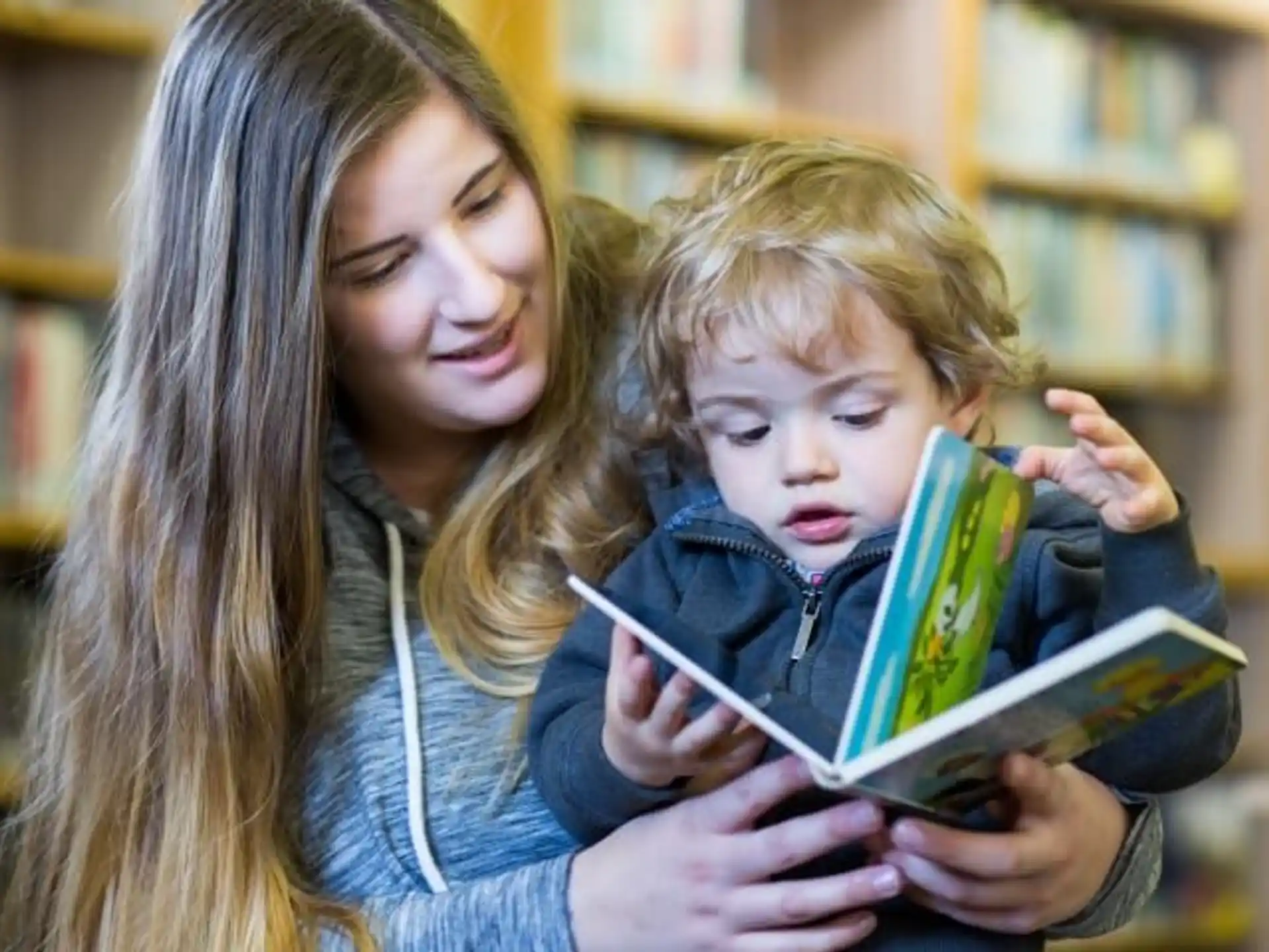 a person reading a book to a child